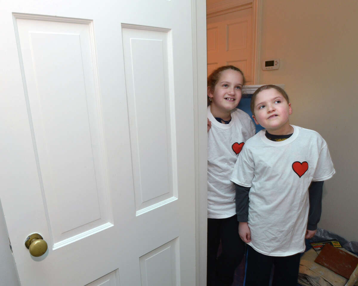 At right, Zach Libow, 7, who is battling leukemia, and his sister, Jordyn, 10, look on as Art from the Heart volunteers use paint to transform Zach's bedroom into an undersea world at his Riverside home, Saturday, March 29, 2014. The Art from the Heart volunteers are a part of the program of Circle of Care for Families of Children with Cancer, which does room makeovers for young cancer patients throughout southern Connecticut and northern Westchester County.