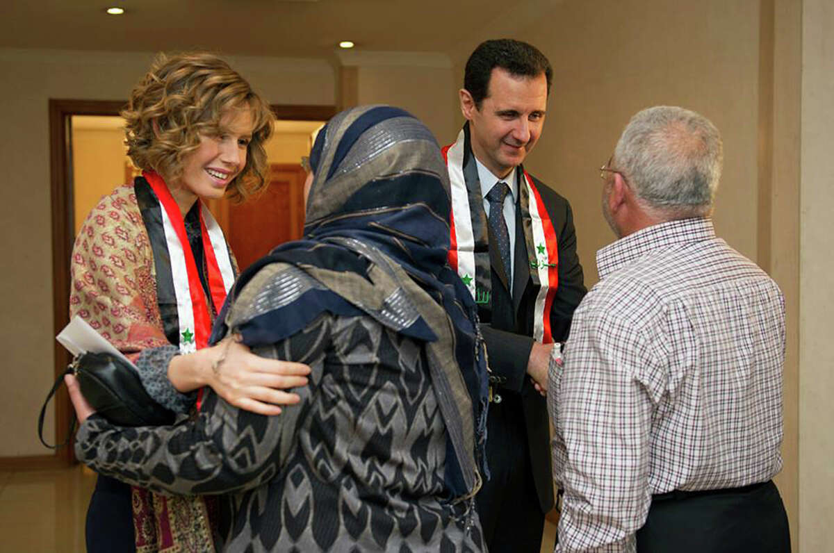 Syria's first lady Asma Assad, left, and President Bashar Assad, greet teachers in Damascus. The Assads recently have made several carefully scripted appearances.