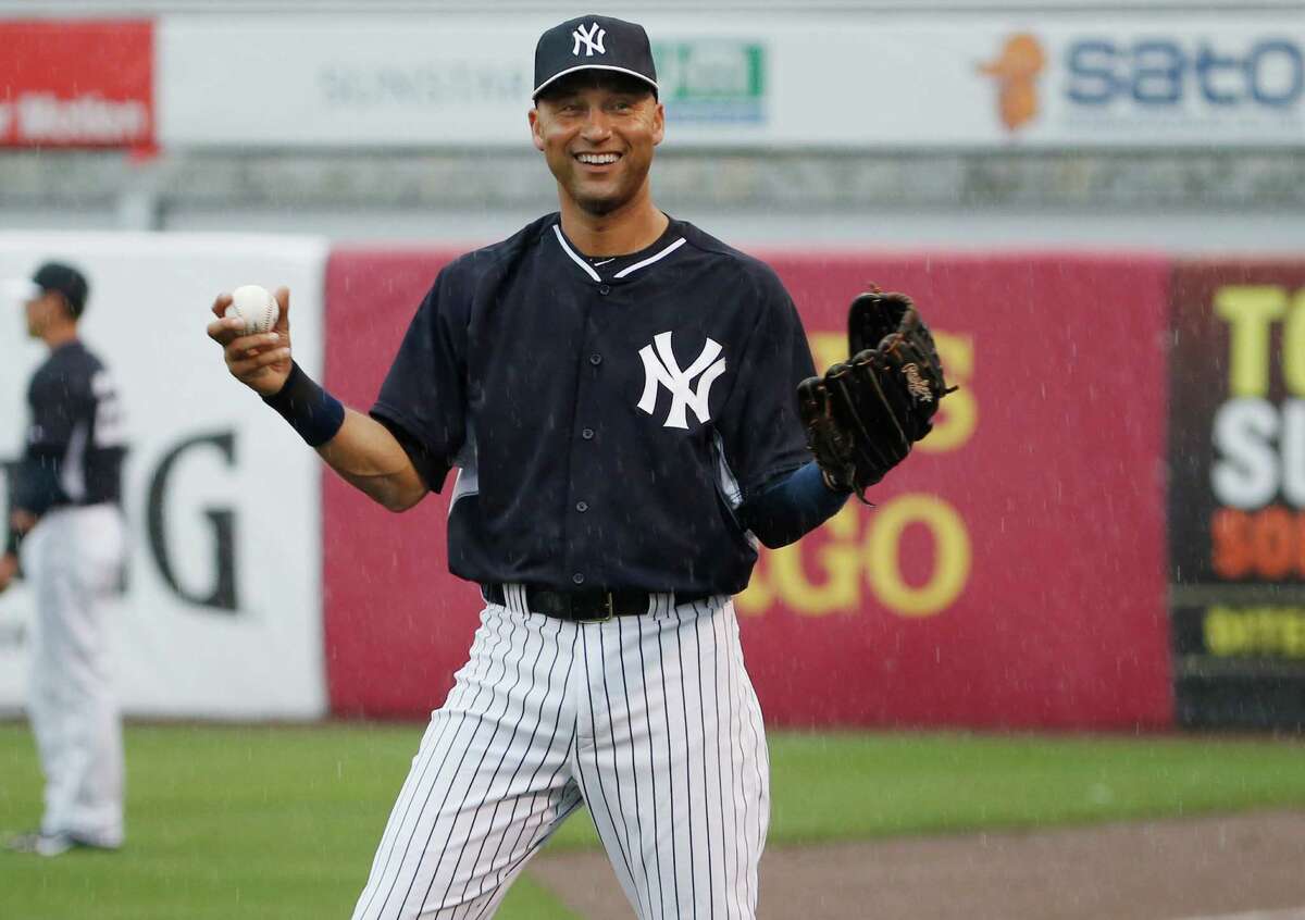 New York Yankees Derek Jeter laughs as he throws in the rain before a spring exhibition baseball game against the Miami Marlins was canceled due to the weather in Tampa, Fla., Saturday, March 29, 2014. (AP Photo/Kathy Willens) ORG XMIT: FLKW108