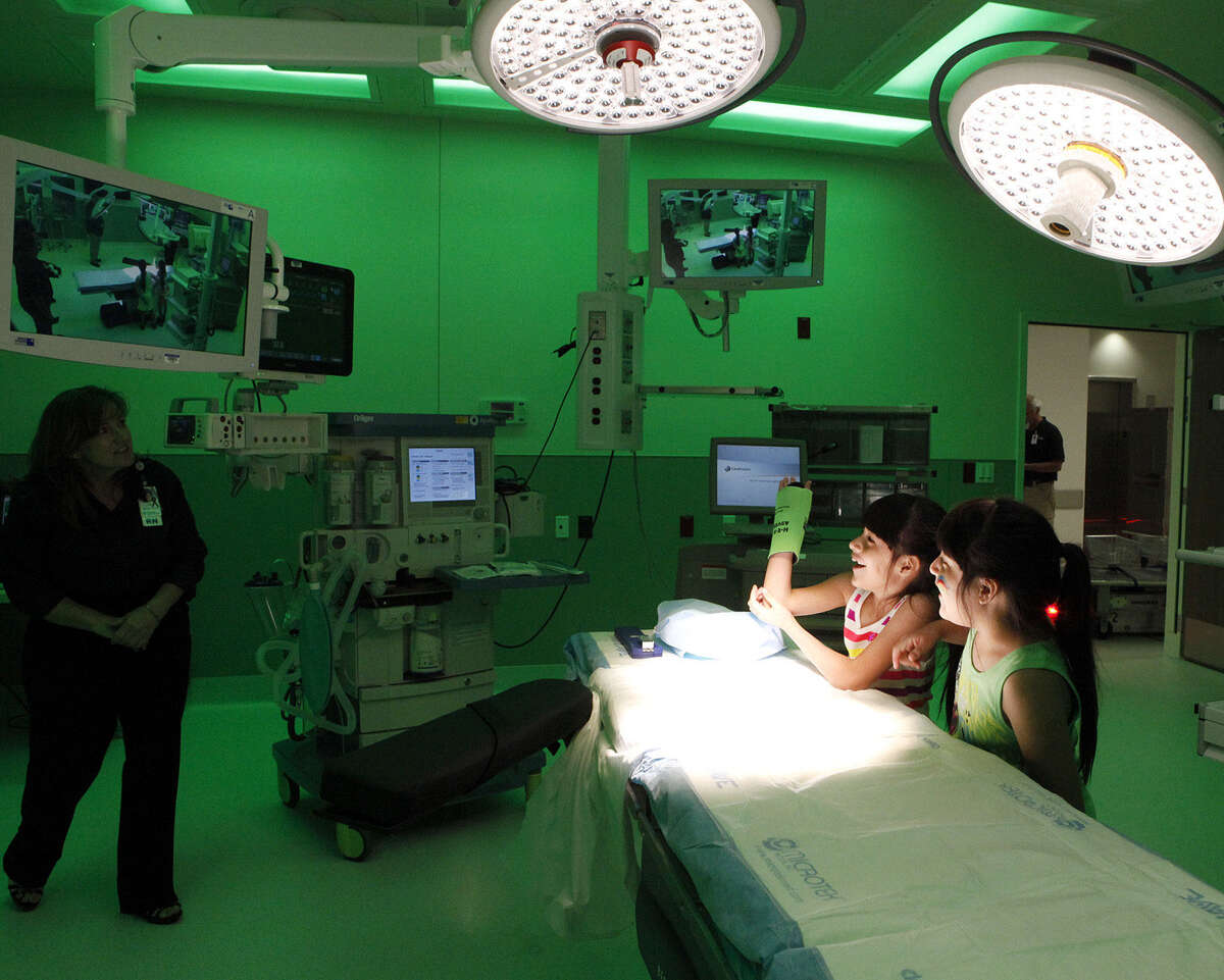 Twins Megan (left) and Alexis Rodriguez, 8, watch themselves on the monitors in one of the operating rooms at University Hospital's Sky Tower and ask questions during a tour.