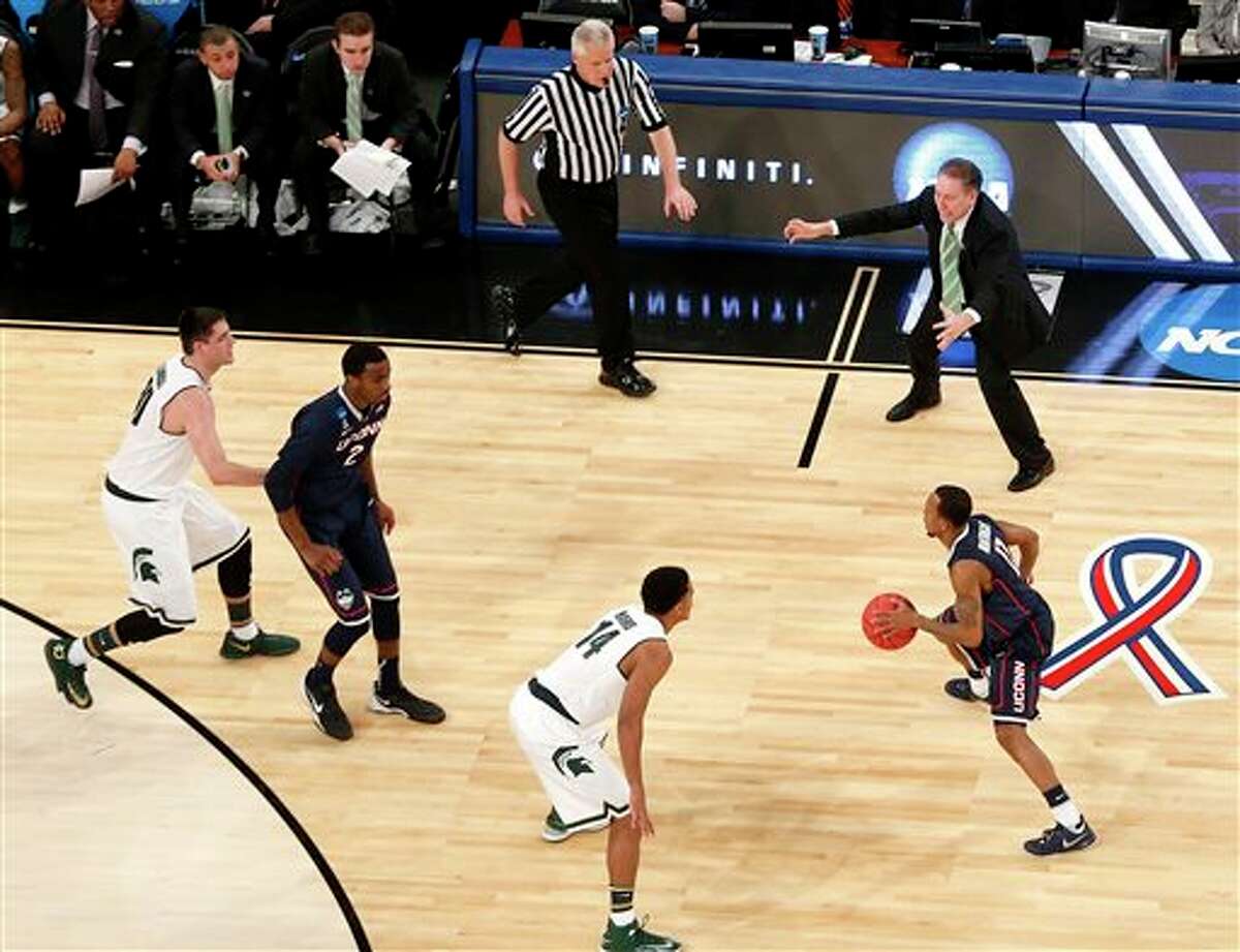 Michigan State head coach Tom Izzo, top right, talks to his team during the first half in a regional semifinal at the NCAA college basketball tournament against Connecticut, Sunday, March 30, 2014, in New York. (AP Photo/Julio Cortez)