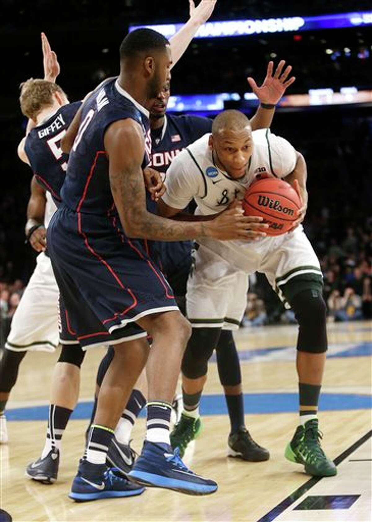 Michigan State's Adreian Payne, right, tries to move the ball past Connecticut's Phillip Nolan in the first half of a regional final at the NCAA college basketball tournament on Sunday, March 30, 2014, in New York. (AP Photo/Frank Franklin II)