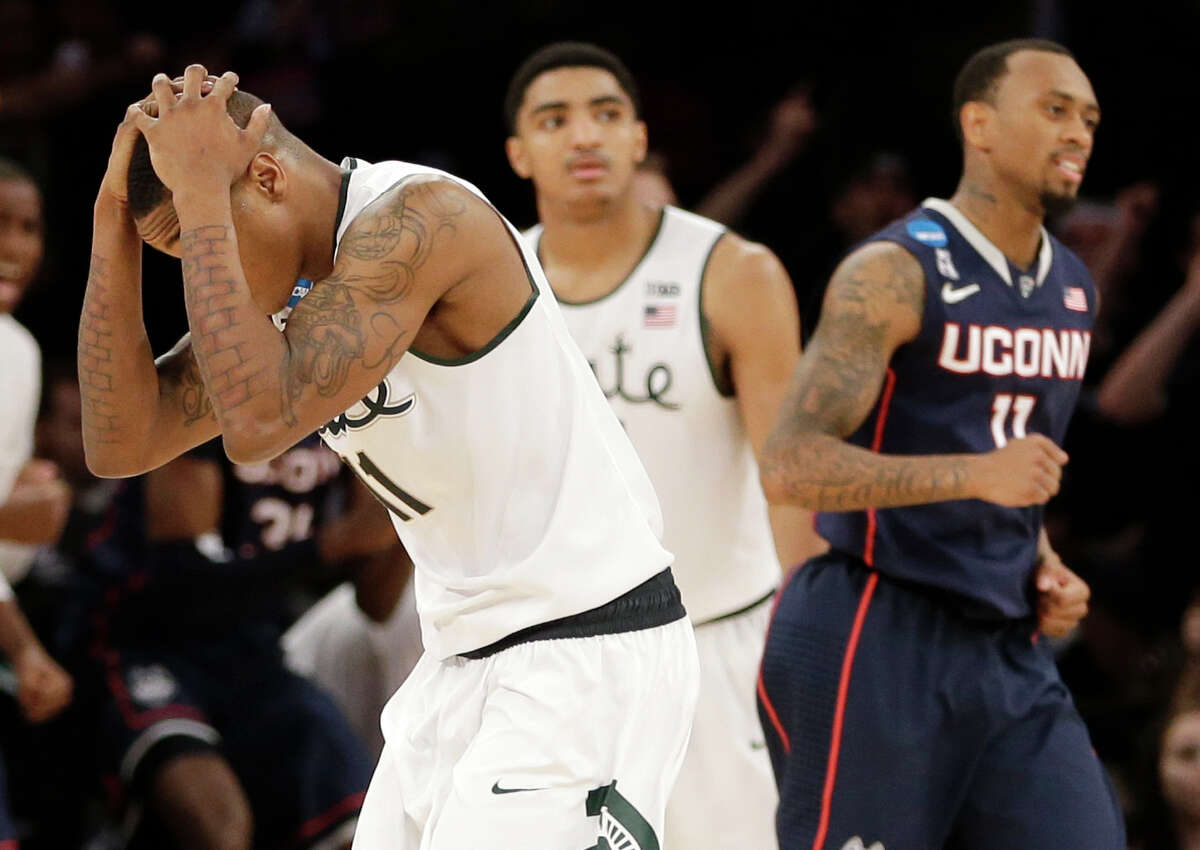Michigan State's Keith Appling, left, and Connecticut's Ryan Boatright go in different directions emotionally as the Huskies finish off their win Sunday.