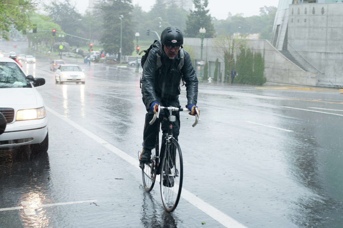 A bicyclist makes his way during a heavy rain downpour in downtown Oakland March 31, 2014.