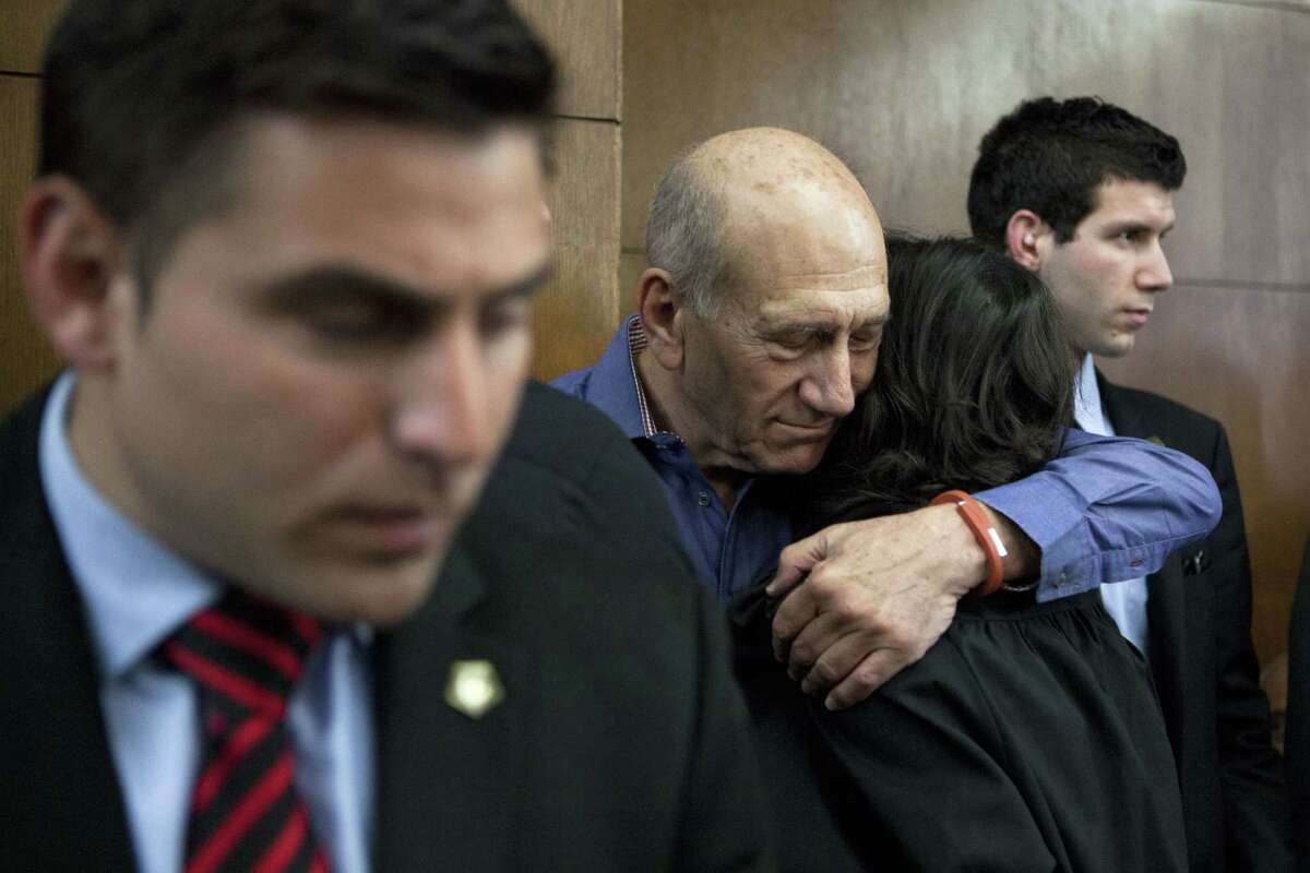 Former Israeli Prime Minister Ehud Olmert hugs a friend before a hearing at Tel Aviv's District Court. Monday, March 31, 2014. The court handed down the verdict in the wide-ranging Jerusalem real estate scandal case related to Olmertâs activities before becoming prime minister in 2006. A total of 13 government officials, developers and other businesspeople were charged in three separate schemes. (AP Photo/Dan Balilty, Pool)