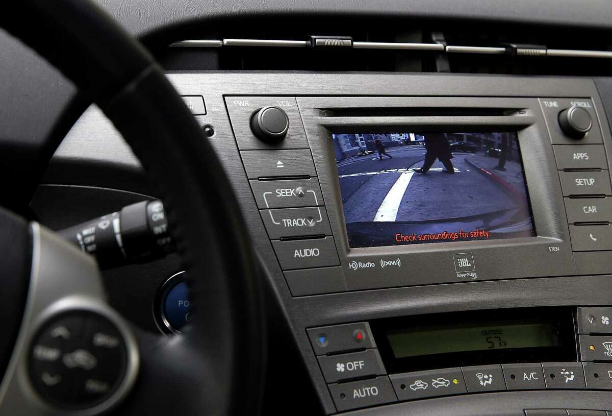 In this photo illustration, pedestrians in San Francisco are shown on the video display of a backup camera of a Toyota Prius.
