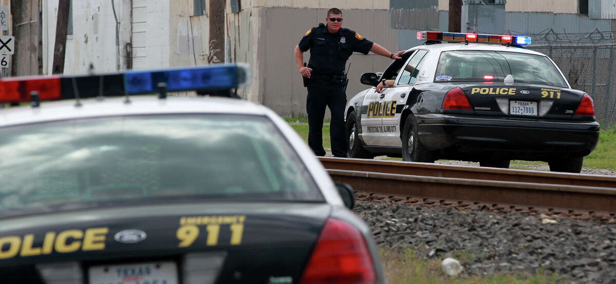 San Antonio police stand by Monday April 1, 2014 near North Comal and Hickman where a man lost several fingers after his hand was run over by a Union Pacific freight train. San Antonio Fire Department public information officer Deborah Foster said a man in his 30s tried to place a penny under the wheel of the moving train to flatten the penny out. The man was transported to an area hospital.