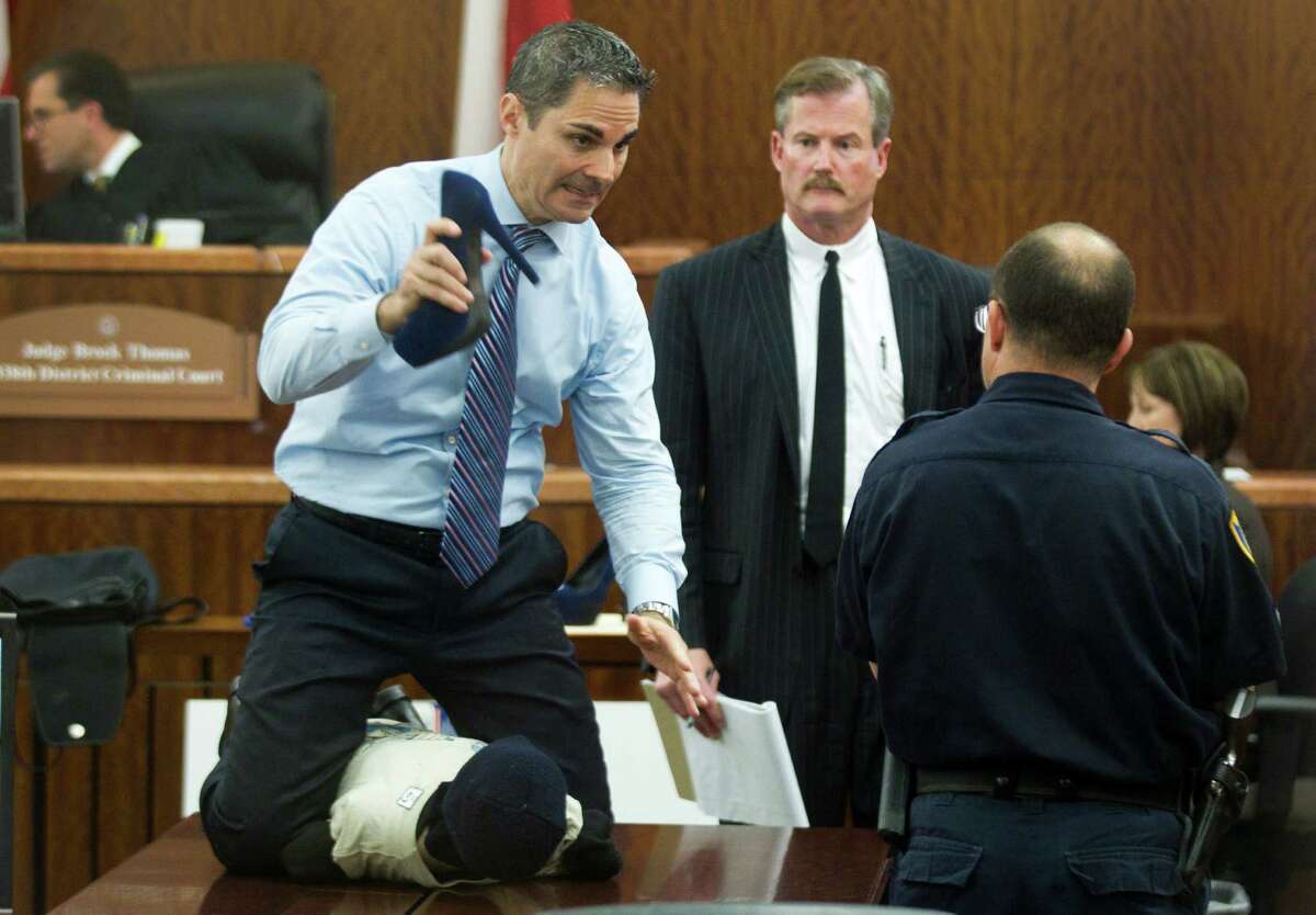 Prosecutor John Jordan does a crime scene demonstration, using a dummy, during the trial against Ana Lilia Trujillo Tuesday, April 1, 2014, in Houston. Trujillo, 45, is charged with murder, accused of killing her 59-year-old boyfriend, Alf Stefan Andersson with the heel of a stiletto shoe, at his Museum District high-rise condominium in June 2013. Defense attorney Jack Carroll, center, and crime scene investigator Christopher Duncan are shown in the background.