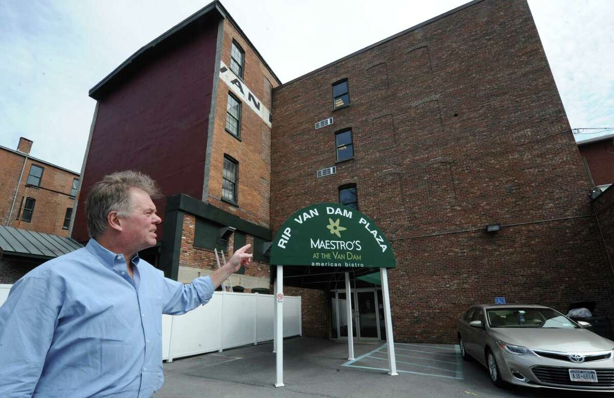 Building partner Jim Quinn points to the rear of the more than 160-year-old Rip Van Dam hotel on Wednesday, April 2, 2014 in Saratoga Springs N.Y. Just the rear part of the building will be taken down. Quinn is one of a handful of developers renovating 16 rooms of the hotel and adding a 160-room hotel and five-story parking garage to the downtown area. The parking lot he is standing in will be where the newer part of the hotel will be. (Lori Van Buren / Times Union)