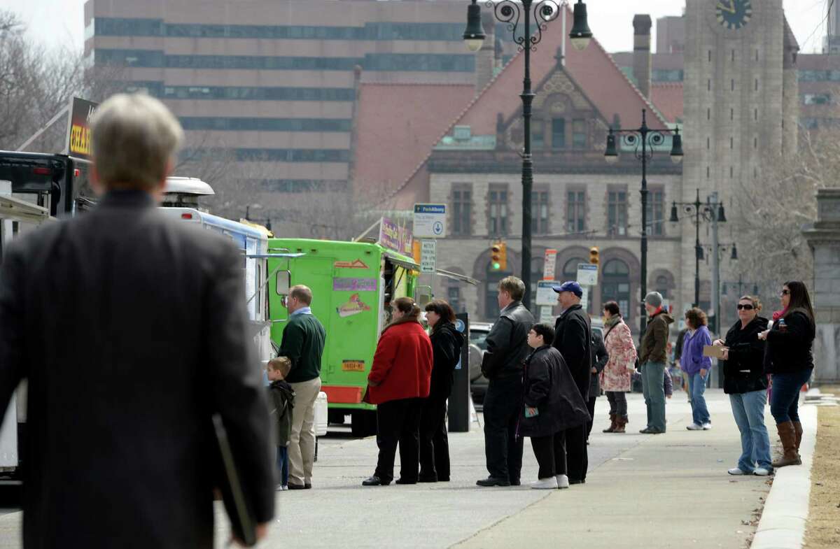 Workers enjoy the weather and the mobile food providers on Washington Avenue Wednesday April. 2, 2014, in Albany, N.Y. (Skip Dickstein / Times Union)