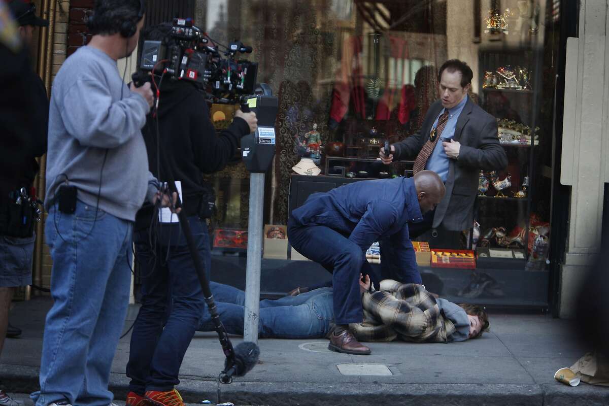 Actor Taye Diggs (center right in blue jacket), acts in a scene of TNT's "Murder in the First" along with Raphael Sbarge (top right) and Nick Gehlfuss (bottom right) while shooting a scene in San Francisco's Chinatown district on Monday, March 24, 2014, in San Francisco, Calif.