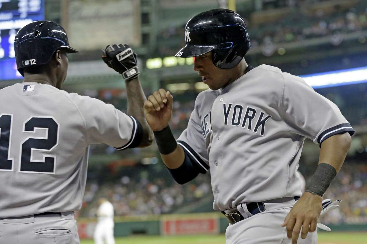 New York's Yangervis Solarte (right) greets Alfonso Soriano after scoring on a sacrifice fly in Houston.