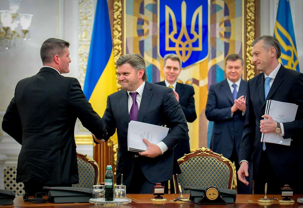 (L-R sit) Chevron's General Manager for Europe Derek Magness , Ministrer of Ecology and Natural Resources of Ukraine Eduard Stavytsky and Viktor Ponomarenko, Chairman of the National Joint Stock Company "Nadra Of Ukraine" sign documents as (rear-standing) Geoffrey Pyatt, US Ambassador to Ukraine, and President of Ukraine Viktor Yanukovych (C) attend during the ceremony in Kiev on November 5, 2013.Ukraine and US energy giant Chevron signed a $10-billion shale gas deal on Tuesday that the ex-Soviet nation hopes could end its energy dependence on Russia by 2020. The production-sharing agreement allows Chevron to explore the Olesky deposit in western Ukraine that Kiev estimates can hold 2.98 trillion cubic meters of gas. AFP PHOTO/ PRESIDENTIAL PRESS-SERVICE POOL/ MYKHAYLO MARKIV (Photo credit should read MYKHAYLO MARKIV/AFP/Getty Images)