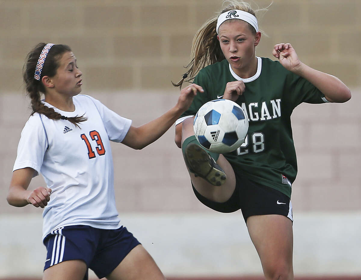 Reagan's Taylor Olson keeps the ball away from Brandeis' Kelsey Kohler during the Rattlers' easy victory in a Class 5A playoff match at Farris Stadium. Olson scored in the triumph.