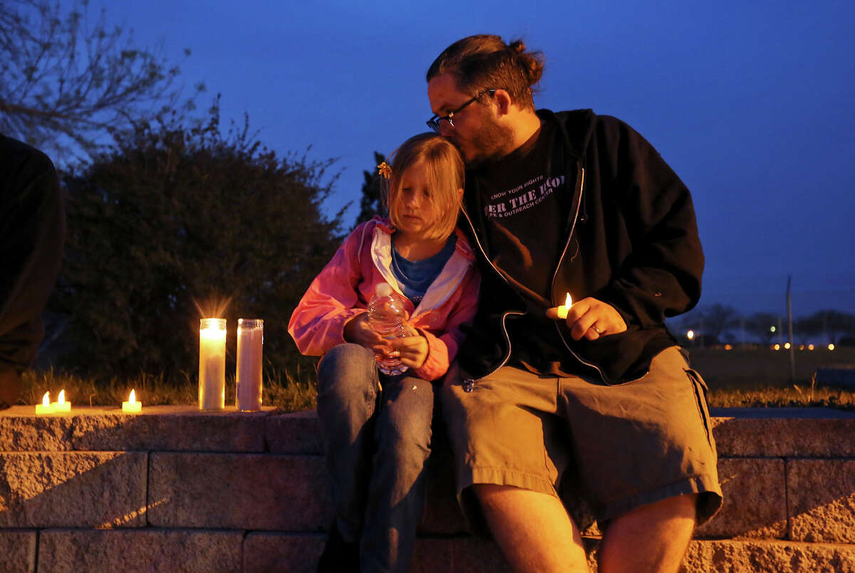 Lily Muncy, 9, (left) and her father Malachi Muncy take part in a candle light vigil for the Fort Hood shooting victims at the east gate Friday April 4, 2014 in Killeen, Texas.