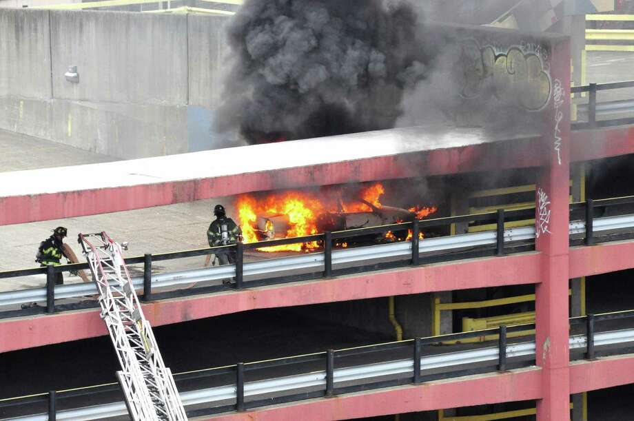 Firefighters respond to a car fire on the parking garage above the Capital Reperatory Theatre in Albany on Saturday afternoon. (Steve Barnes / Times Union)