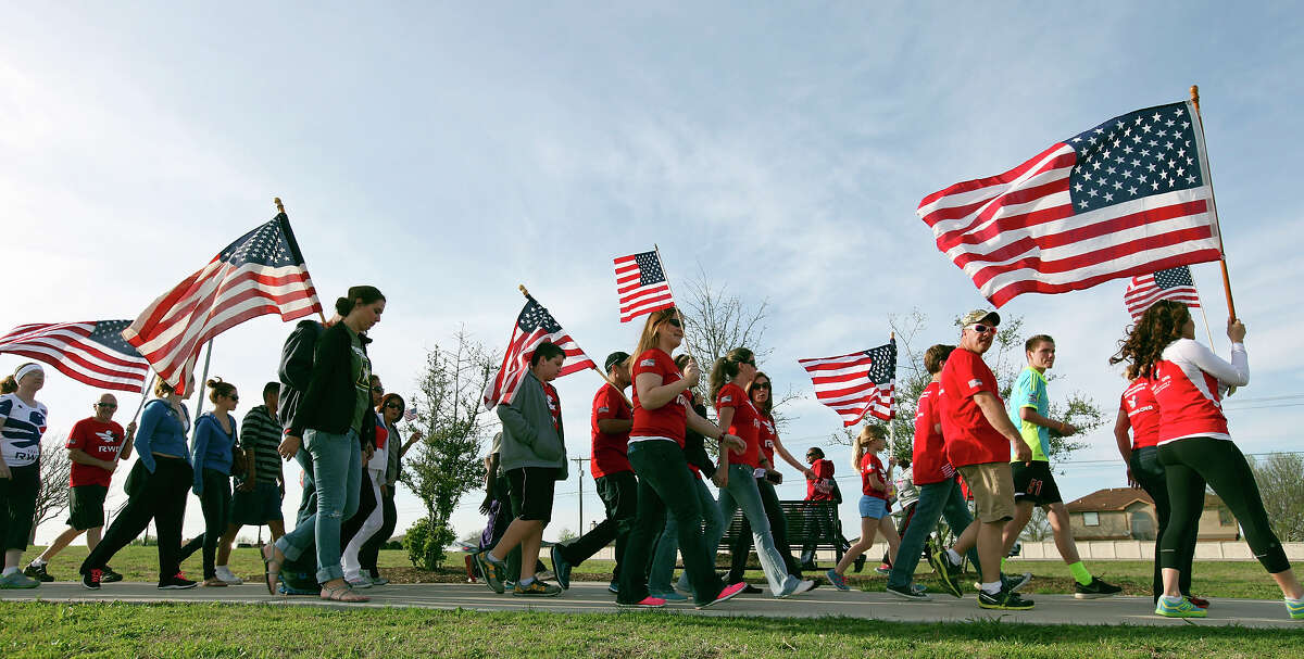 People take part in a flag walk around Lions Club Park in tribute to the Fort Hood shooting victims Friday April 4, 2014 in Killeen, Texas.