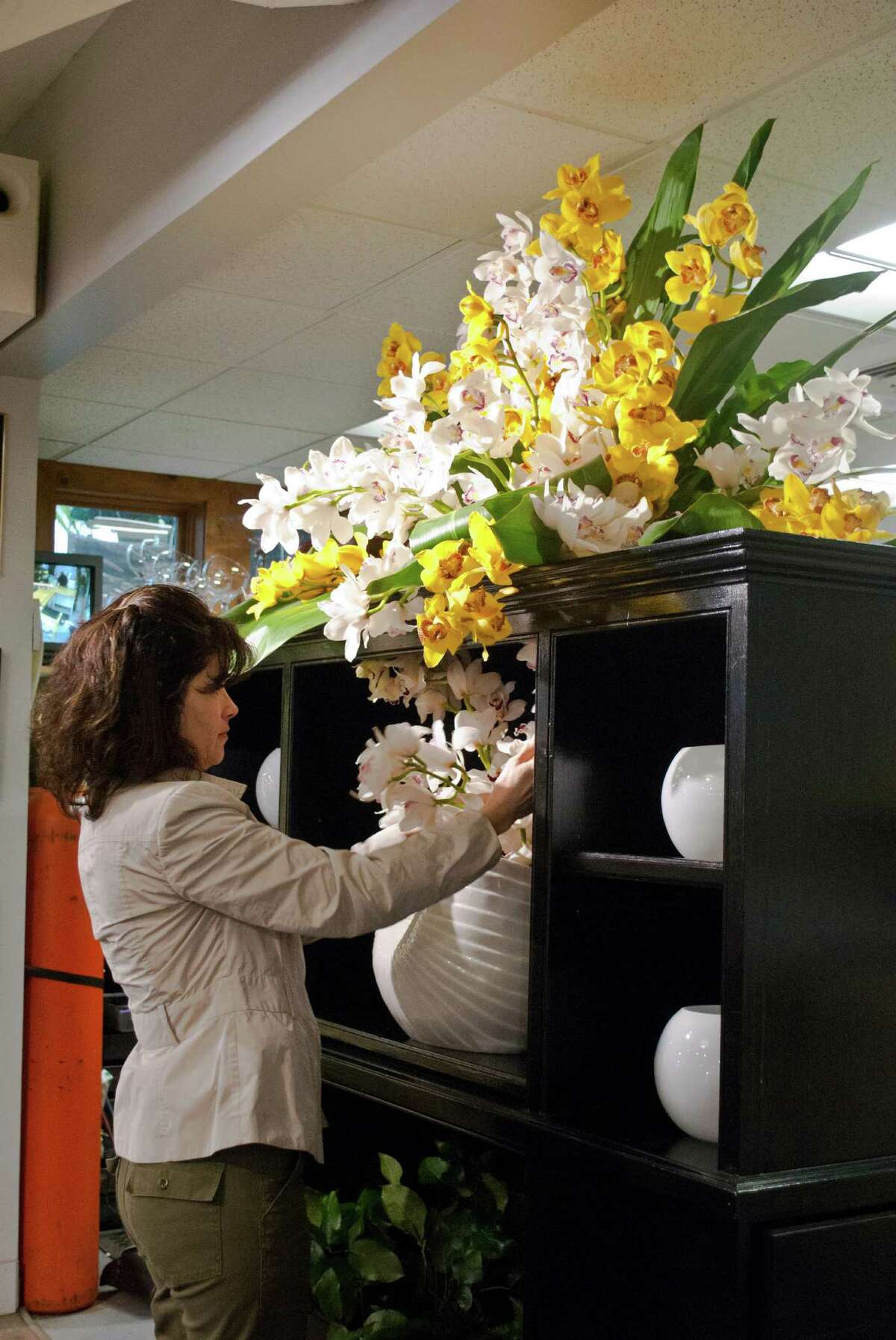 Nielsen's Florist and Garden Shop in Darien held a flower show to celebrate their 70 year anniversary of being in business from April 4-6. Dana Burwell, from New Canaan, adjusts one of the displays.