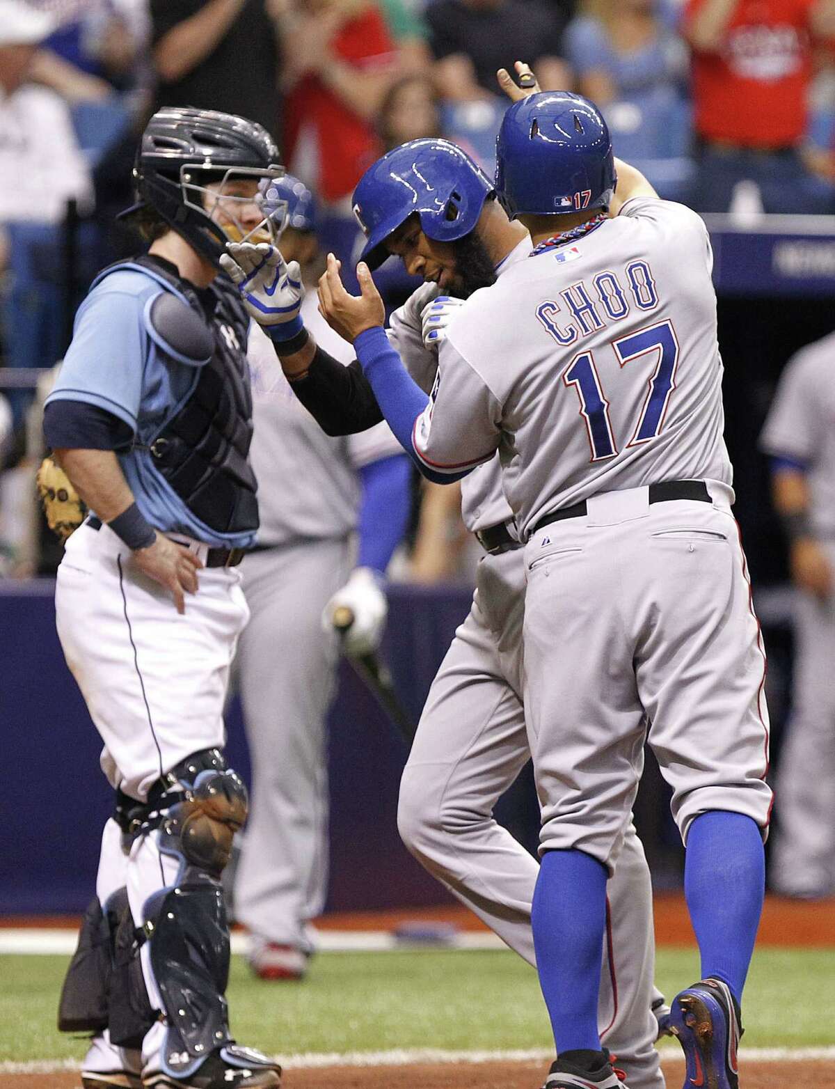 The Rangers' Elvis Andrus (center) is congratulated by Shin-Soo Choo after his two-run homer in the eighth as Rays catcher Ryan Hanigan watches.