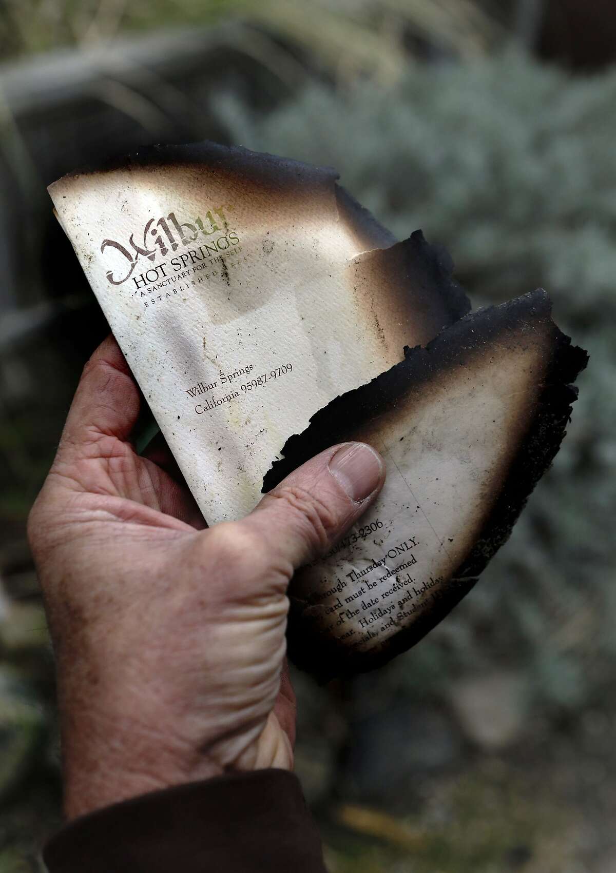 Maintenance worker Joel Main holds pieces of burned stationary from the lodge, on Friday April 4, 2014, near Williams, Calif. The owners and employees of Wilbur Hot Springs, the historic and beloved hot springs in Colusa County, are still mopping up and accessing the damage after the old lodge was destroyed by a fire last weekend.