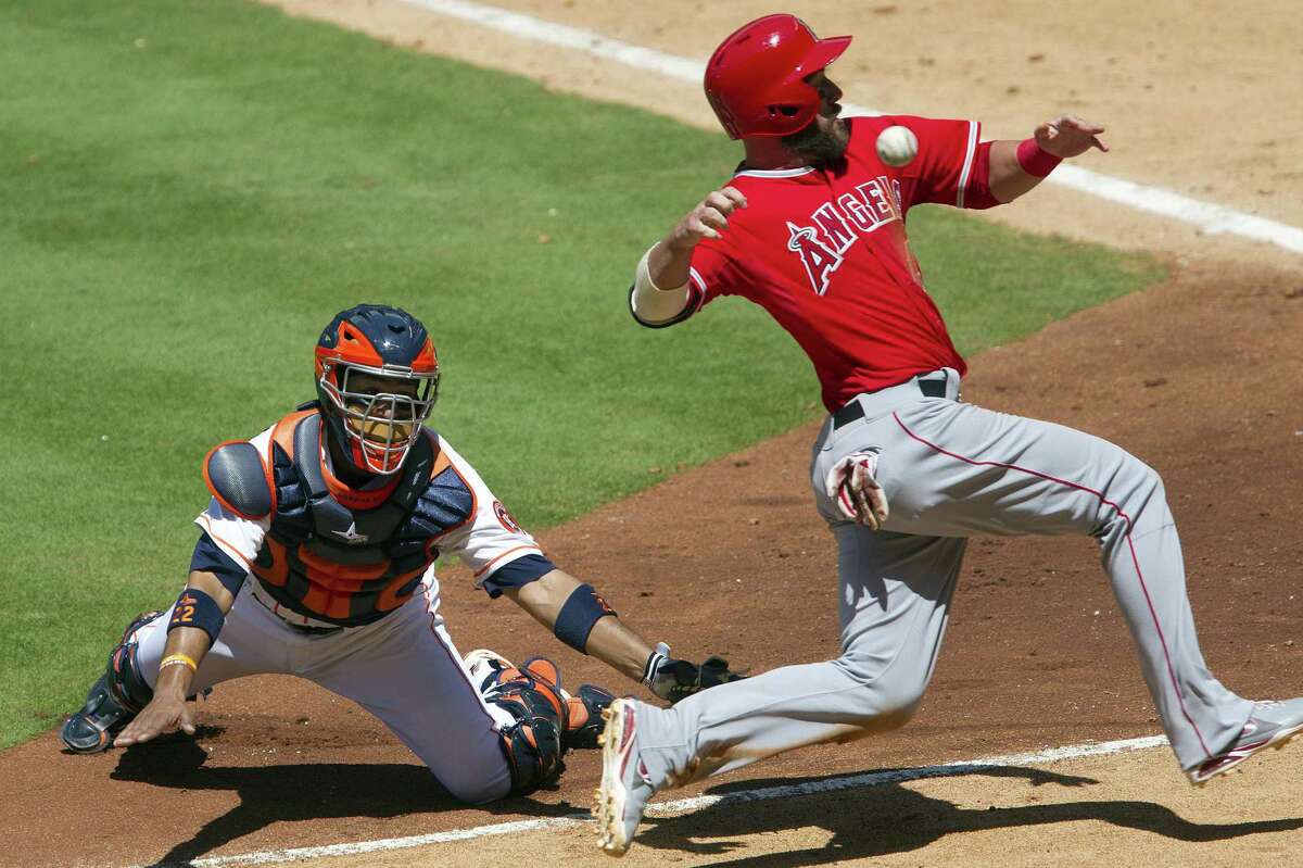 Astros catcher Carlos Corporan misses a catch that allows the Angels' Ian Stewart to score in the sixth.