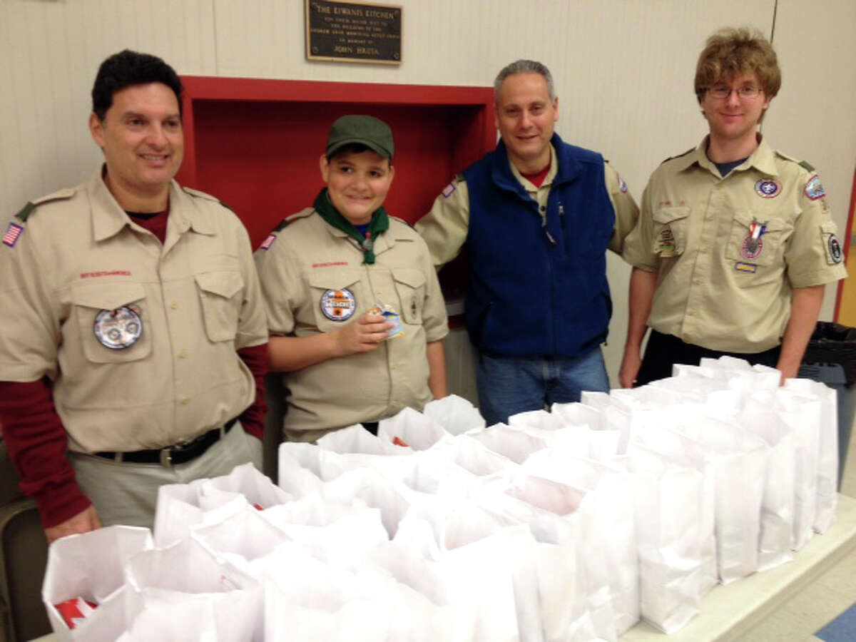 Reuben Keating, JonCarlo Keating, Patrick Gentile and Eagle scout Nicholas Reynoso in front of the brown bag dinners they prepared for the Washington Village Learning Center.