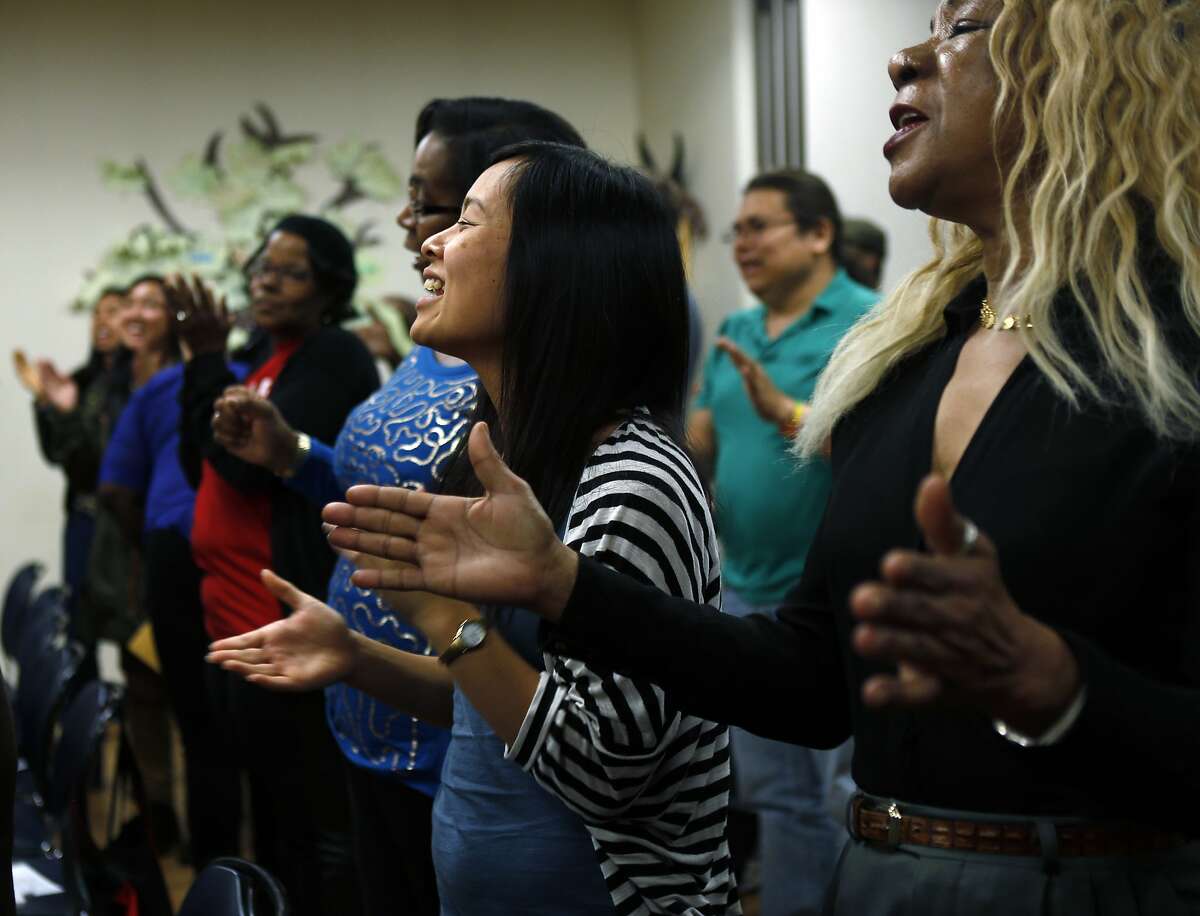 The audience chants and claps at the conclusion of a gathering of health, housing and poverty advocates at the Fruitvale - San Antonio Senior Center in Oakland, Calif., on Monday, April 7, 2014. The group Causa Justa released a report on gentrification and poverty done in collaboration with the Alameda County Public Health Department with over a year's worth of study and data.