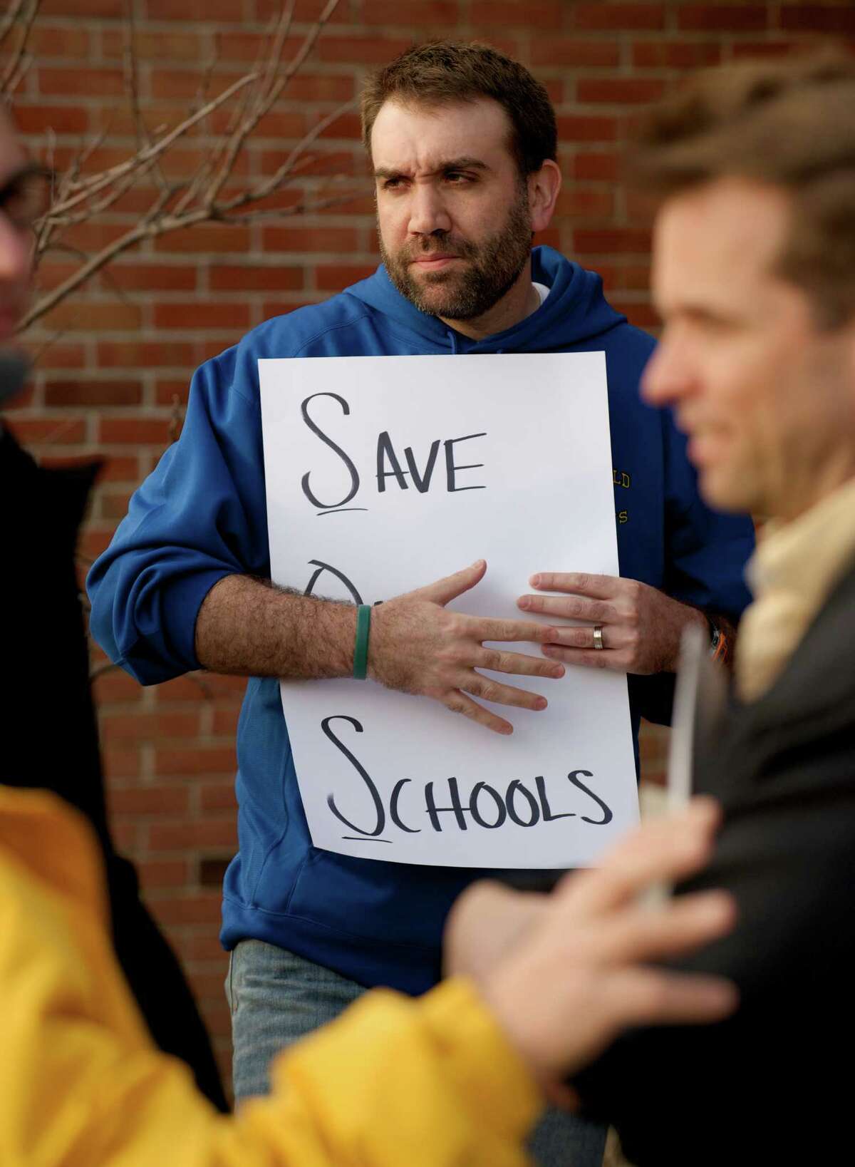 Chris Buckley, 35, of Brookfield, holds a sign asking to "Save Our Schools" during a parents and education staff rally to increase funding for the Brookfield, Conn school system, which was held before the Board of Finance public hearing, at Brookfield High School on Tuesday, April 8, 2014. Buckley has two children who will be students in the Brookfield School System.