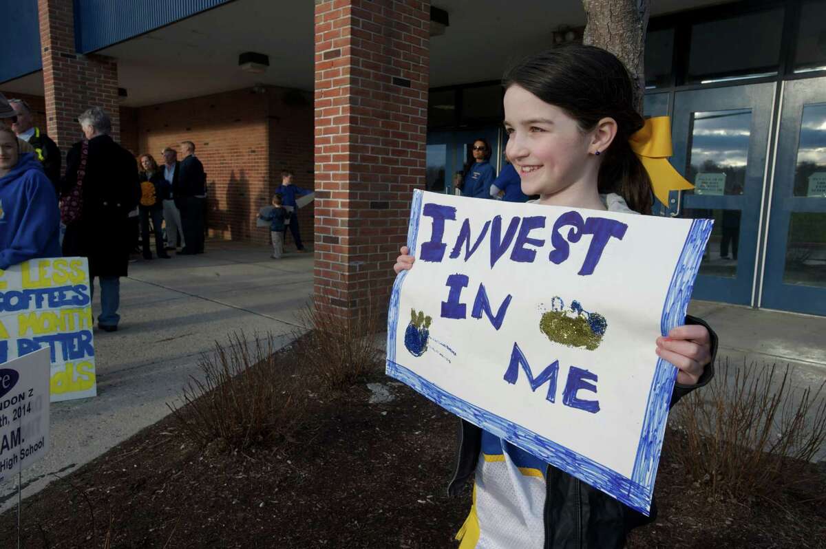 Kayla Zimmerman, 8, a Brookfield second grader holds up a sign during a parents and education staff rally to increase funding for the Brookfield, Conn school system before the Board of Finance public hearing at Brookfield High School on Tuesday, April 8, 2014.