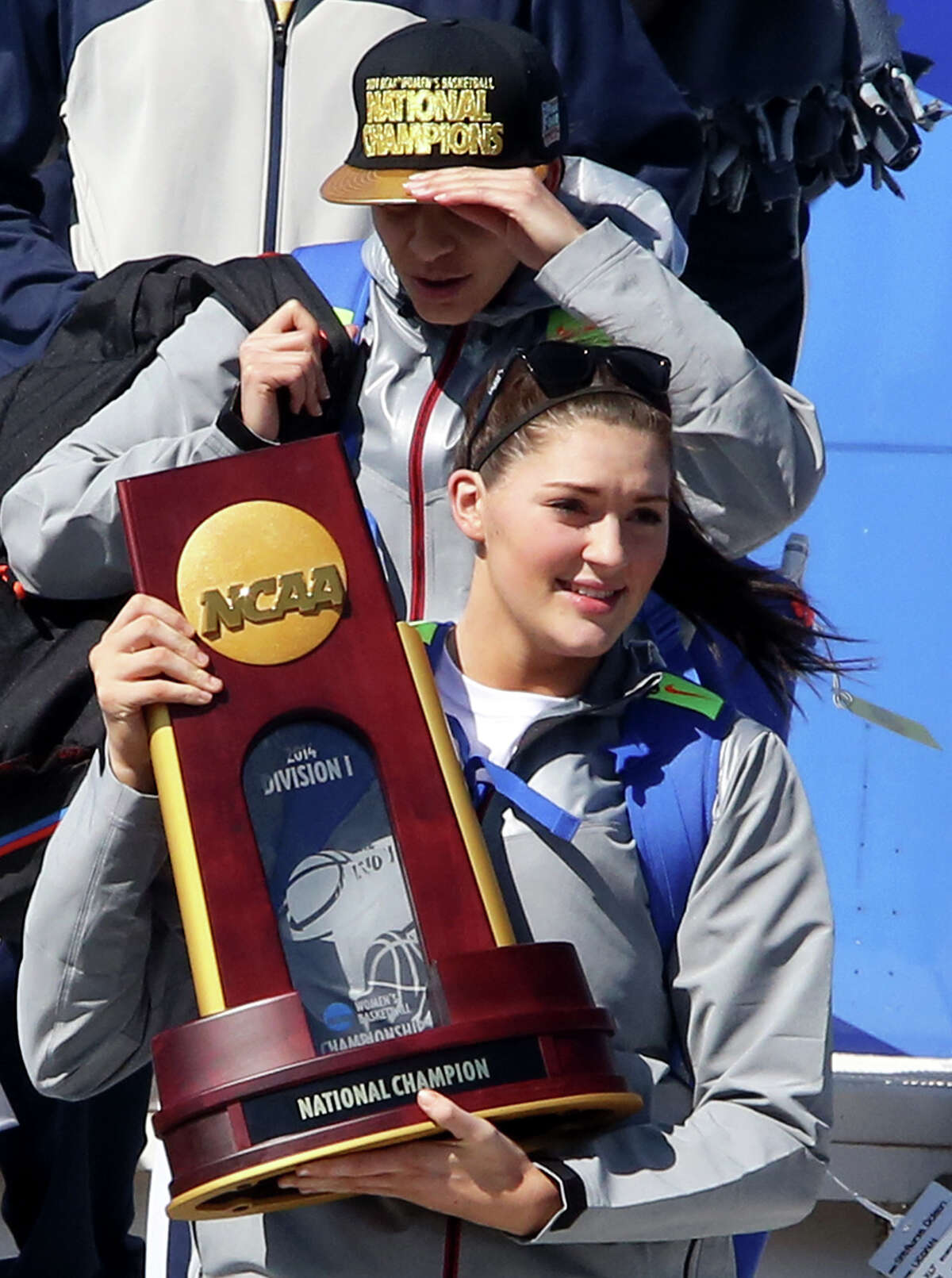 Connecticut's Stephanie Dolson holds the NCAA National Championship Trophy to fans as the team arrives at Bradley International Airport in Windsor Locks, Conn., Wednesday, April 9, 2014, the day after the Huskies defeated Notre Dame to clinch their ninth national championship. (AP Photo/Journal Inquirer, Jared Ramsdell) MANDATORY CREDIT