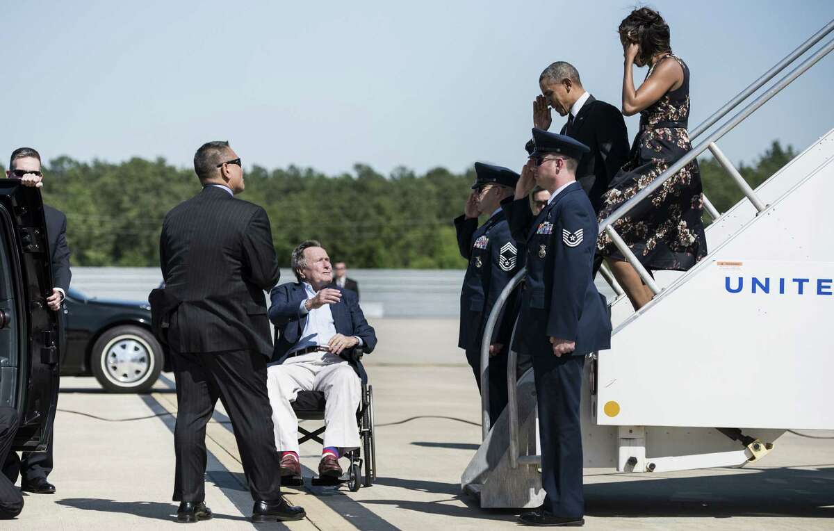 Former President George H.W. Bush welcomes President Obama and first lady Michelle Obama at George Bush Intercontinental Airport in Houston on April 9.