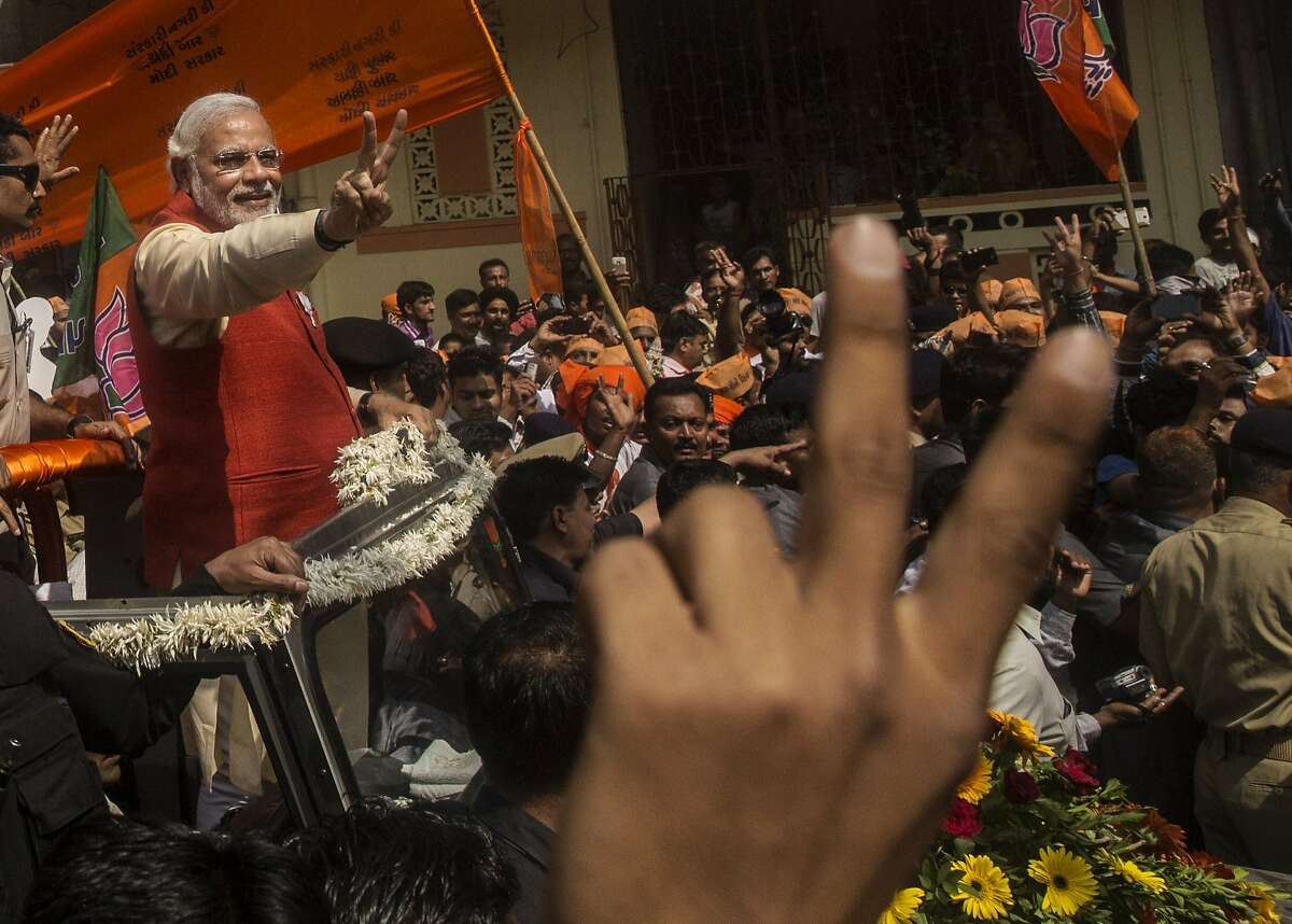 VADODRA, INDIA - APRIL 09: Bharatiya Janata Party (BJP) leader Narendra Modi gestures to supporters as he rides in an open jeep on his way to file nomination papers on April 9, 2014 in Vadodra, India. India is in the midst of a nine-phase election from April 7-May 12. (Photo by Kevin Frayer/Getty Images) *** BESTPIX ***
