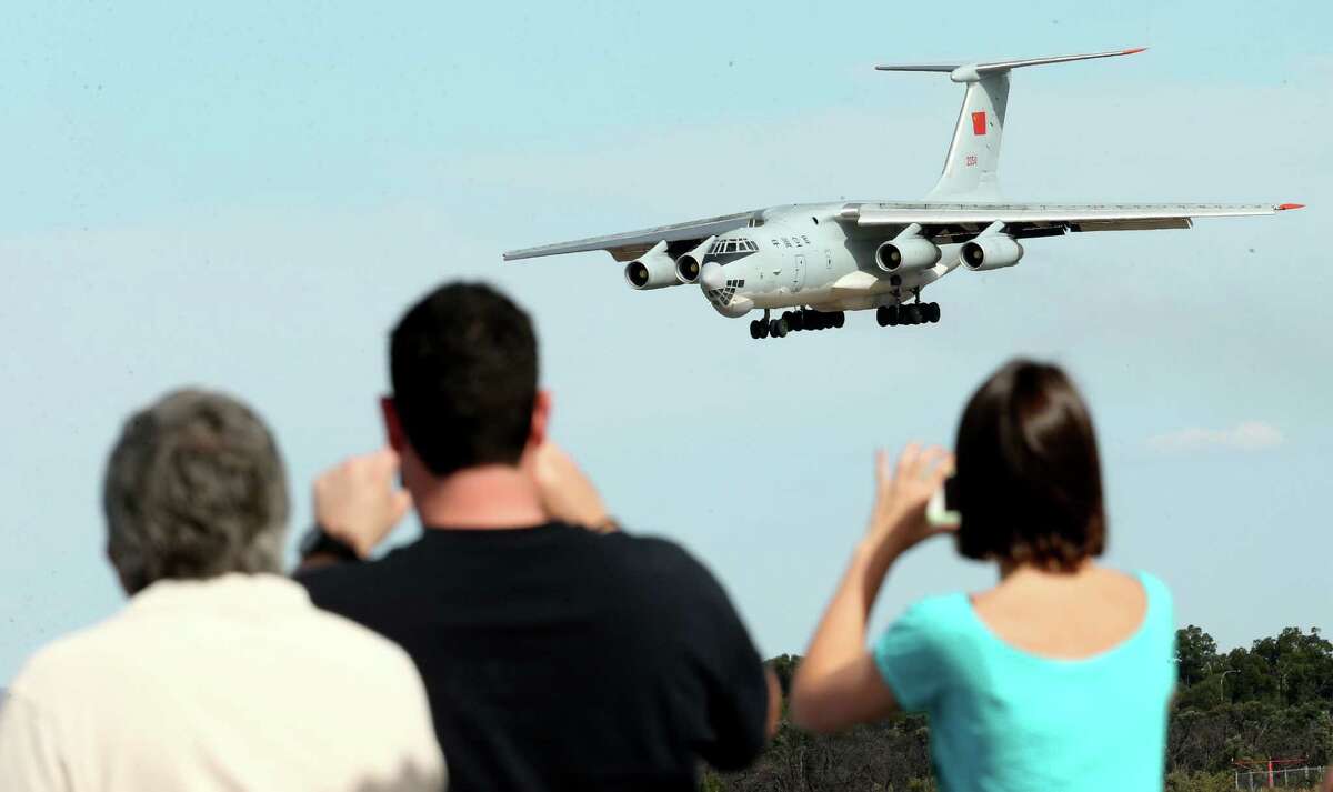 Spectators take photos of a Chinese Ilyushin IL-76 aircraft as it comes in for a landing at Perth International Airport after returning from the ongoing search operations for missing Malaysia Airlines Flight 370 in Perth, Australia, Thursday, April 10, 2014. With hopes high that search crews are zeroing in on the missing Malaysian jetliner's crash site, ships and planes hunting for the aircraft intensified their efforts Thursday after equipment picked up sounds consistent with a plane's black box in the deep waters of the Indian Ocean.