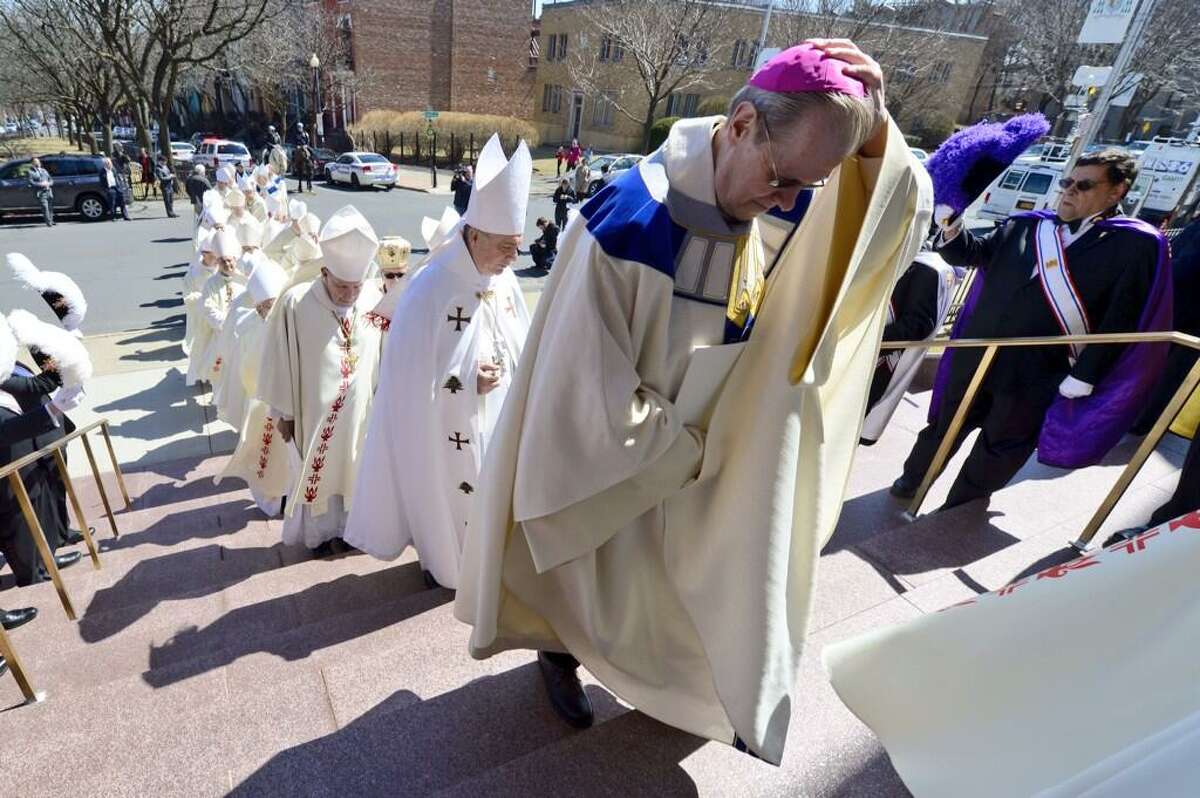 Bishop-elect Edward Scharfenberger holds his skull cap from the wind as he enters the cathedral for his ordination Thursday, April 10, 2014. (Skip Dickstein / Times Union)
