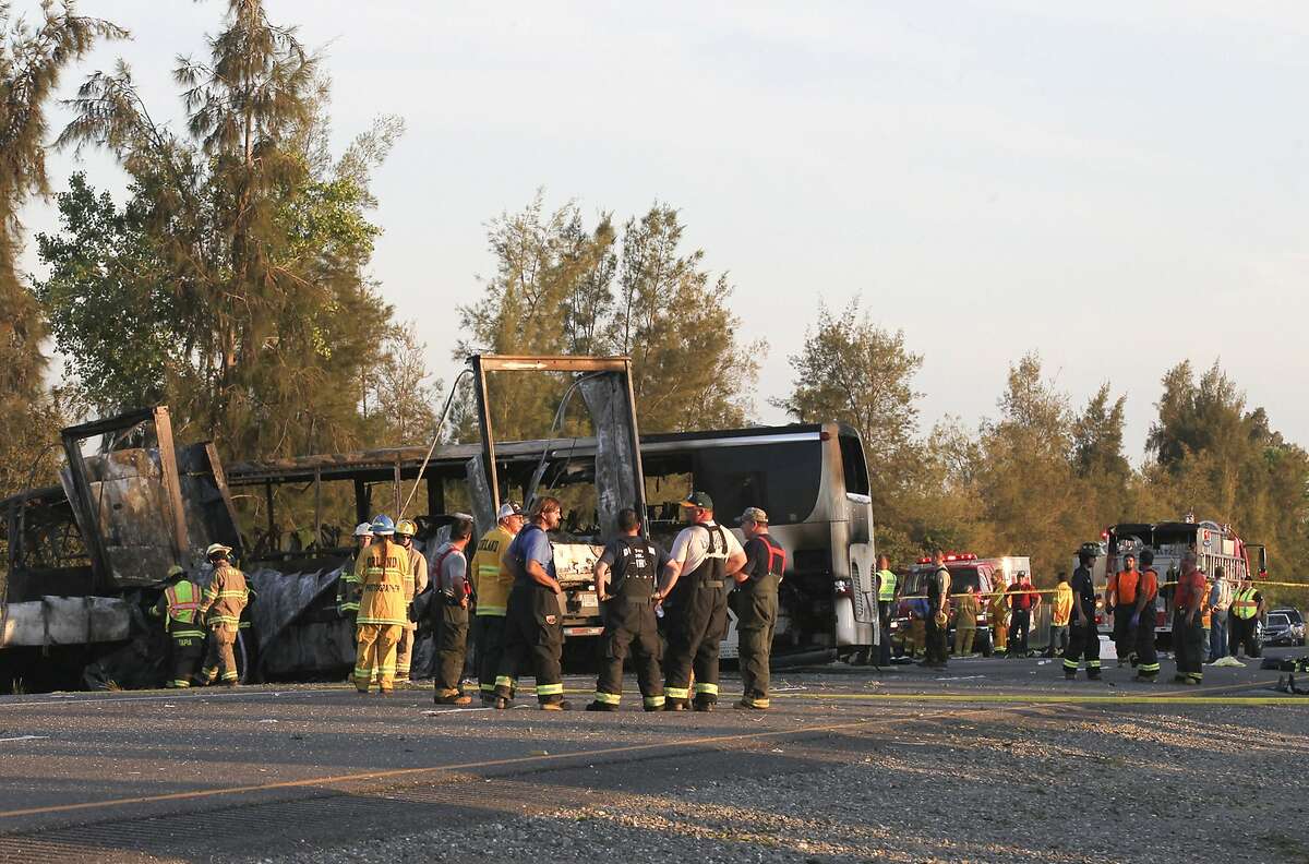 Rescue workers, police and firefighters work the scene where nine people were killed in a three-vehicle crash involving a bus carrying high school students on a visit to a college, Thursday, April 10, 2014, near Orland, Calif. Authorities said it is not yet clear what caused the crash but that it involved a tour bus, a FedEx truck and a Nissan Altima. (AP Photo/The Record Searchlight, Greg Barnette)