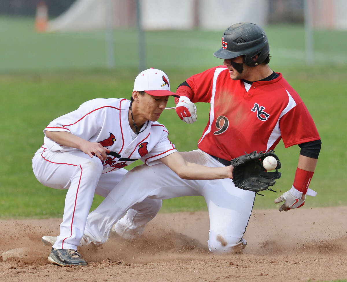 At left, Greenwich shortstop Keigo Fujikura takes the throw but New Canaan's Nick Cascione is safe at second on a steal during the high school baseball game between Greenwich High School and New Canaan High School at Greenwich, Friday afternoon, April 11, 2014.