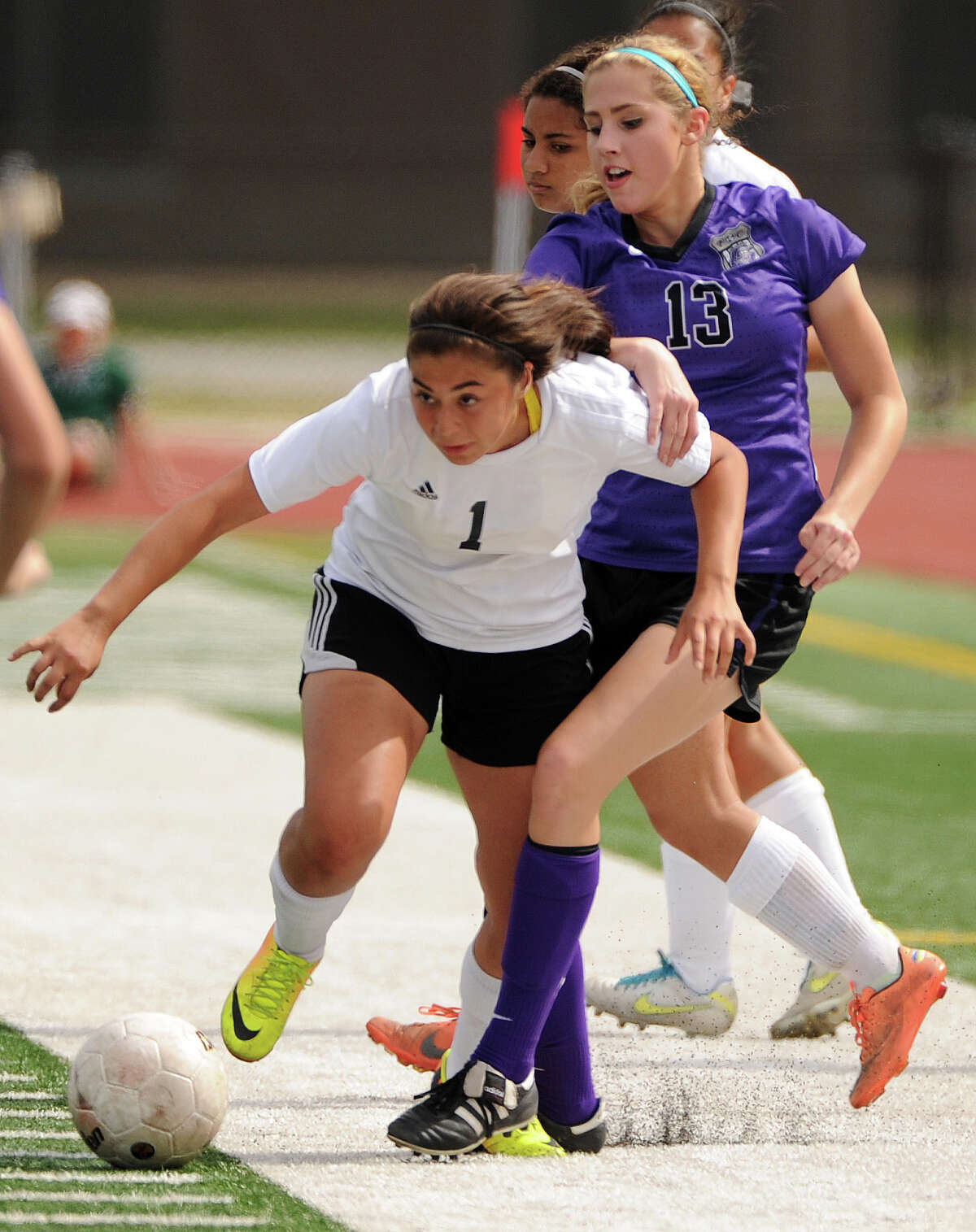 Spring Woods' Natalie Elizondo (1) advances the ball past College Station's Lexi Bullard during the first half of a 4A Region III semifinal high school soccer playoff game, Friday, April 11, 2014, at Turner Stadium in Humble.