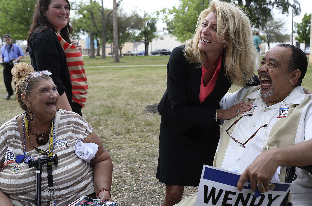 State Sen. Wendy Davis, the Democratic nominee for governor, laughs with supporters Teresa Rivera (left) and Johnny Rankin (right) at Maverick Park in San Antonio.