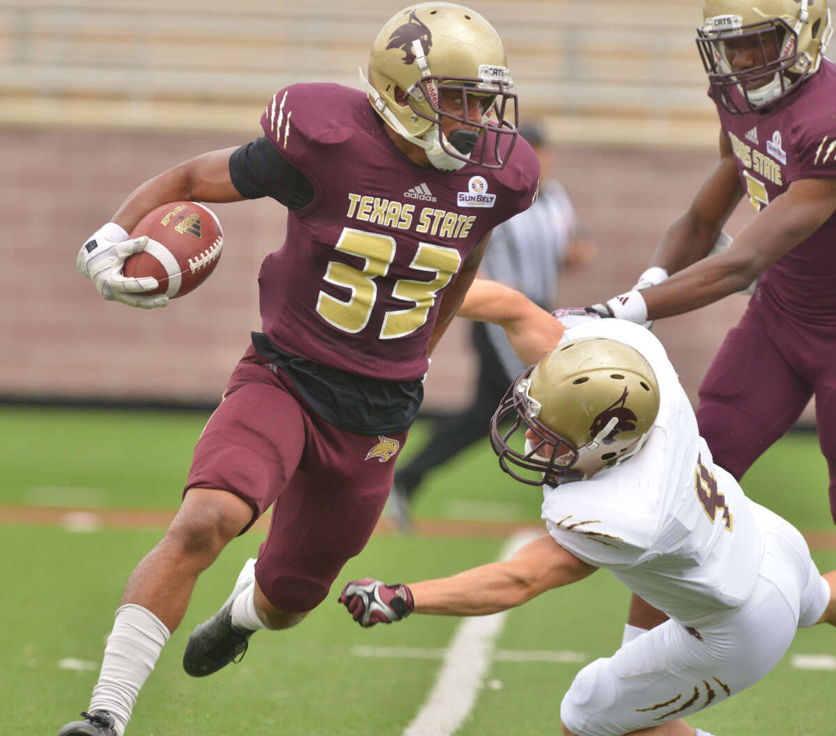 Texas State's David Farris breaks a tackle attempt by Grant Reber on a kickoff return during the annual Maroon and Gold spring game at Bobcat Stadium on Saturday.