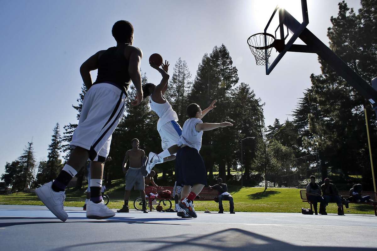 Raunte Colly (wearing white) shoots a basket during a pick up game with friends at Brookdale Park in Oakland, Calif, on Sunday, April 13, 2014. Oakland is considering becoming just the sixth city in the nation to sell naming rights to corporations and the wealthy, as city budgets have slashed budgets for park maintenance and facilities.