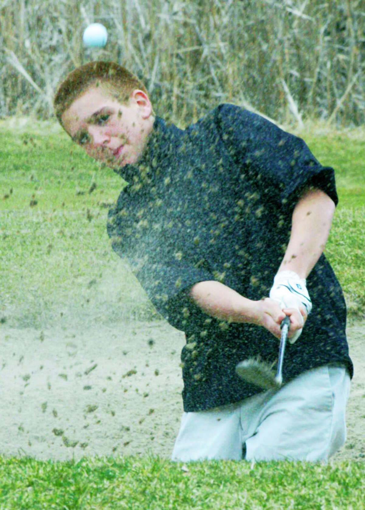 The Green Wave's John Pace blasts his way out of a sand trap during practice at Candlewood Valley Country Club for the New Milford High School golf season. April 2014