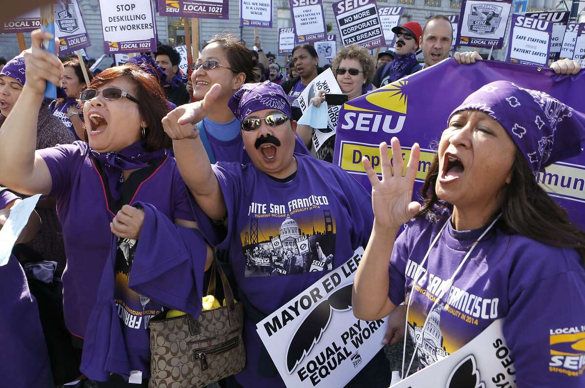 (l to r) Rosalina David, Shawn Campos and Elenor Collemarcine all union workers at Laguna Honda hospital join union workers and supporters as they rally in front of City Hall, on Tuesday April 15, 2014, in San Francisco, Calif. City nurses, janitors and other workers rally in front of city hall to protest the tax breaks that that local high-tech companies are receiving as they move into the Market Street area.
