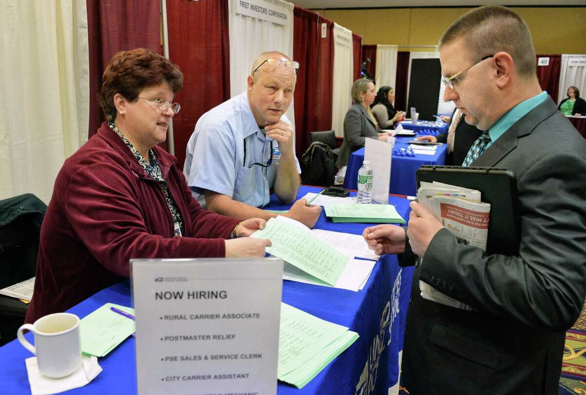 US Postal Service manager for training Patty DiMento, left, and Albany City Carrier Jay Jackson, center, speak with job seeker Robert Weber of Saratoga Springs, right, at the Times Union's spring job fair Wednesday April 16, 2014, at the Albany Marriott in Colonie, N.Y. DiMento say's 'We're hiring like crazy." (John Carl D'Annibale / Times Union)