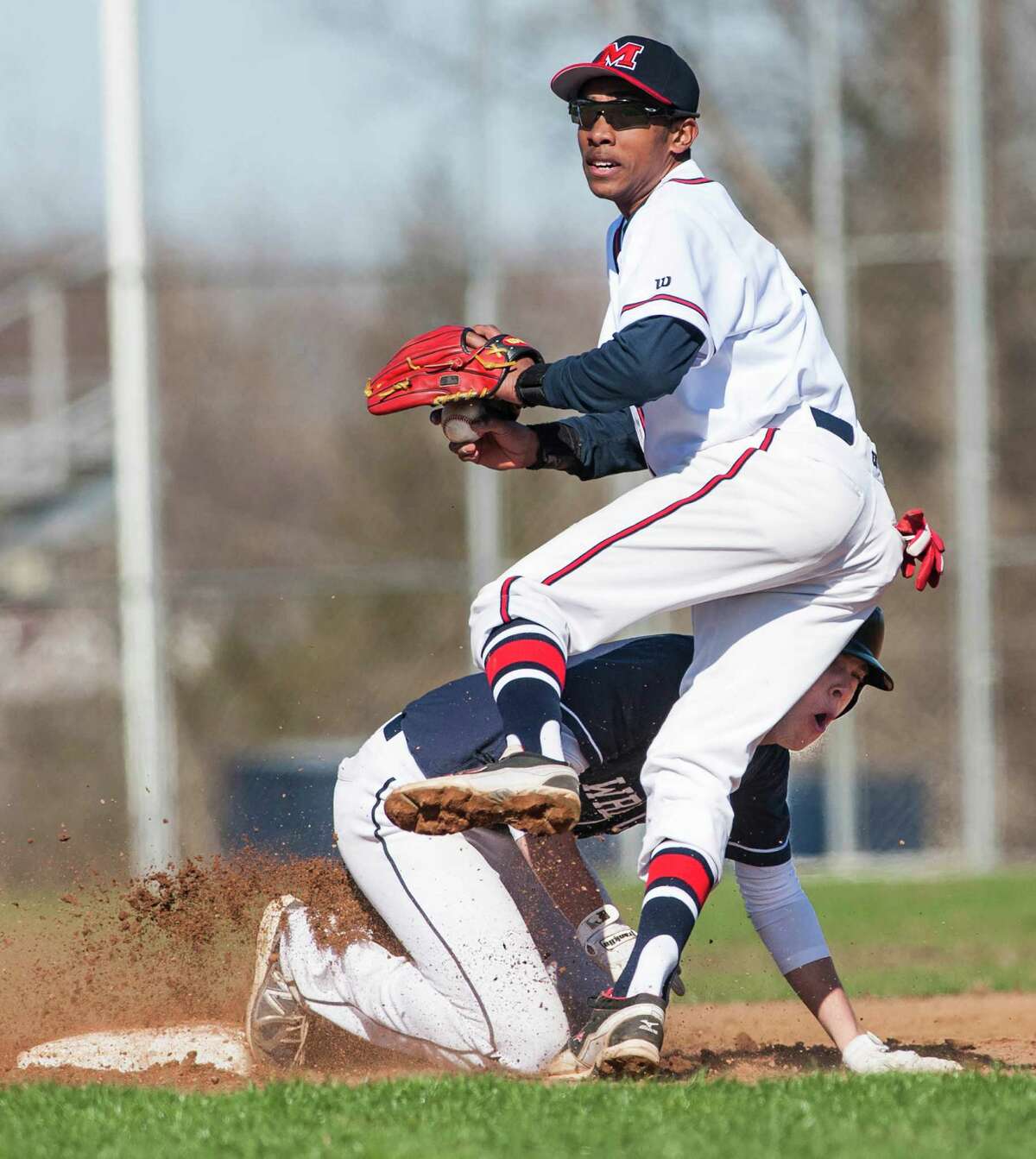 Staples high school's Nathan Panzer runs into Brien McMahon high school shortstop Edwin Owolo while sliding into second base during a boy's baseball game played at Brien McMahon high school, Norwalk, CT on Wednesday, April, 16th, 2014.