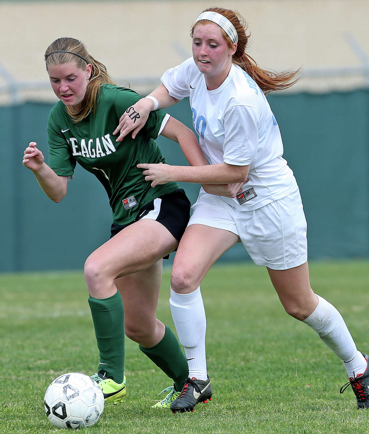 Reagan's Taryn Sherman is pressured by Amber Stearns as Johnson plays Reagan in a 26-5A girls soccer match at Northeast Soccer Stadium on March 14, 2014.