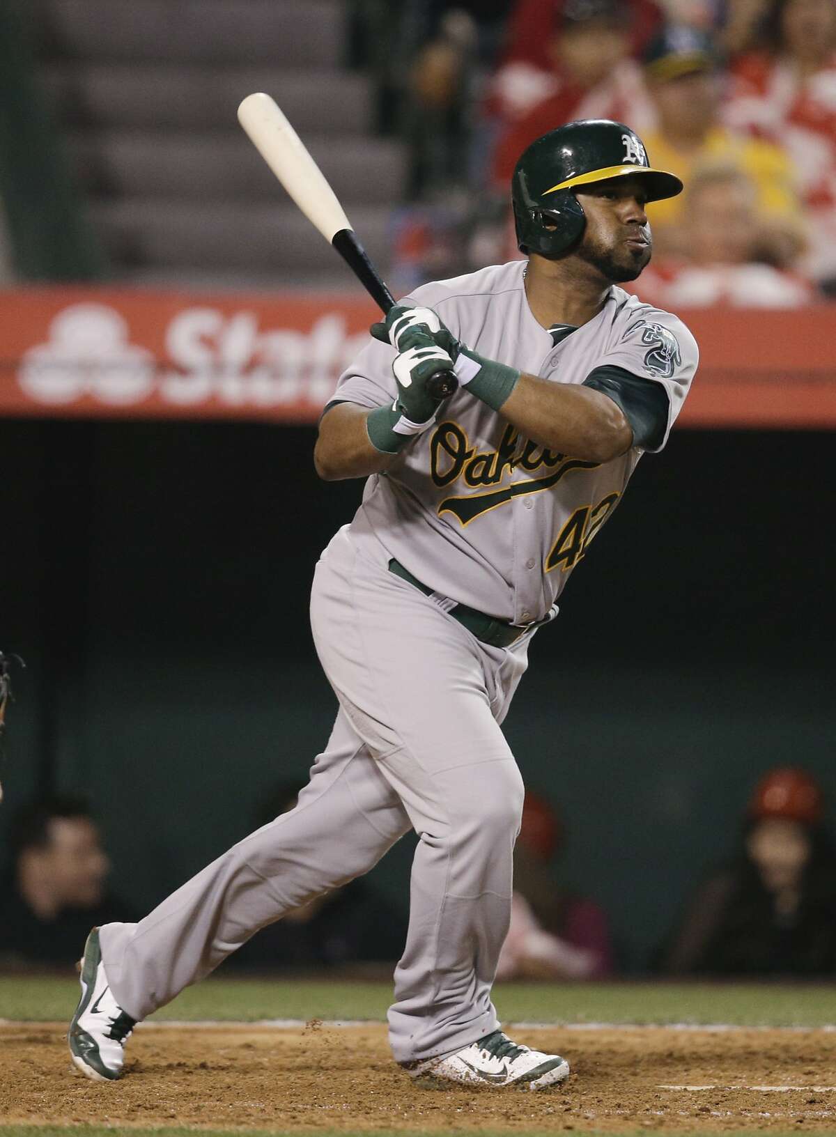 Oakland Athletics' Alberto Callaspo hits a RBI single during the eighth inning of a baseball game against the Los Angeles Angels on Tuesday, April 15, 2014, in Anaheim, Calif. (AP Photo/Jae C. Hong)