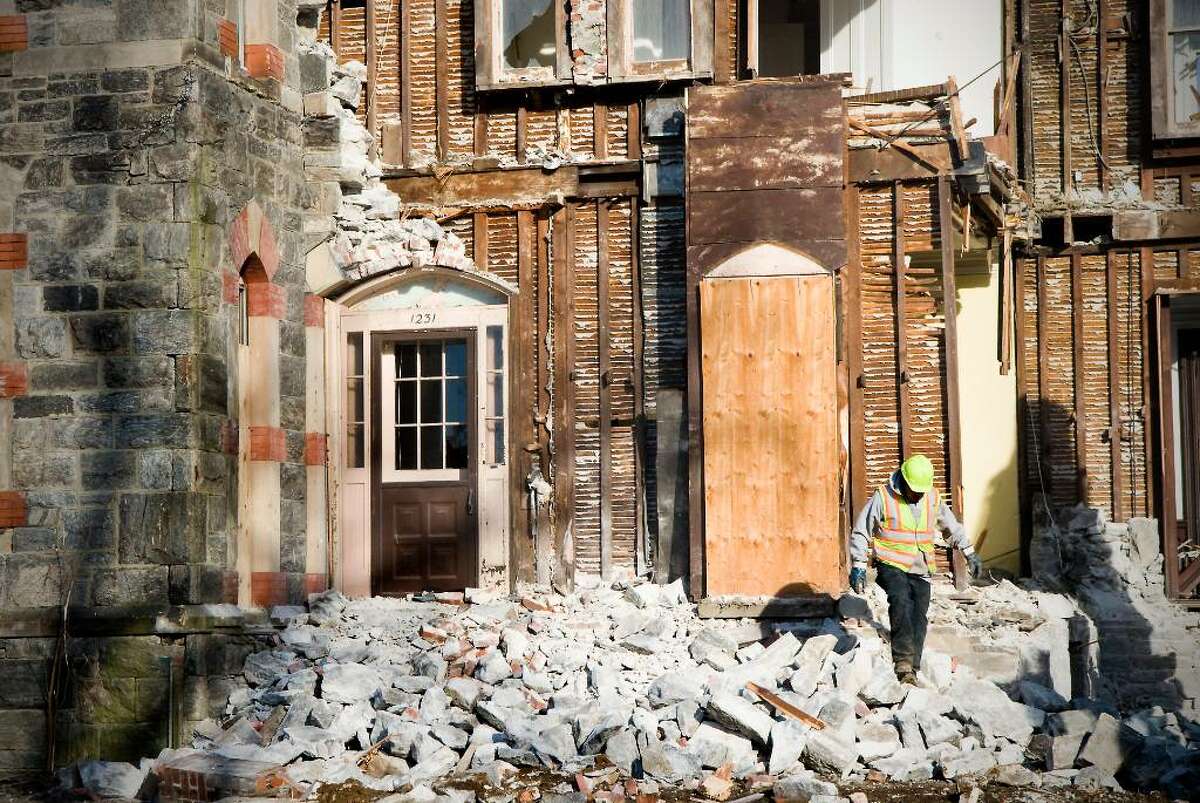 Employees of City Carting & Recycling begin demolition on St. Andrew's rectory in Stamford, Conn. on Thursday, Feb. 11, 2010.