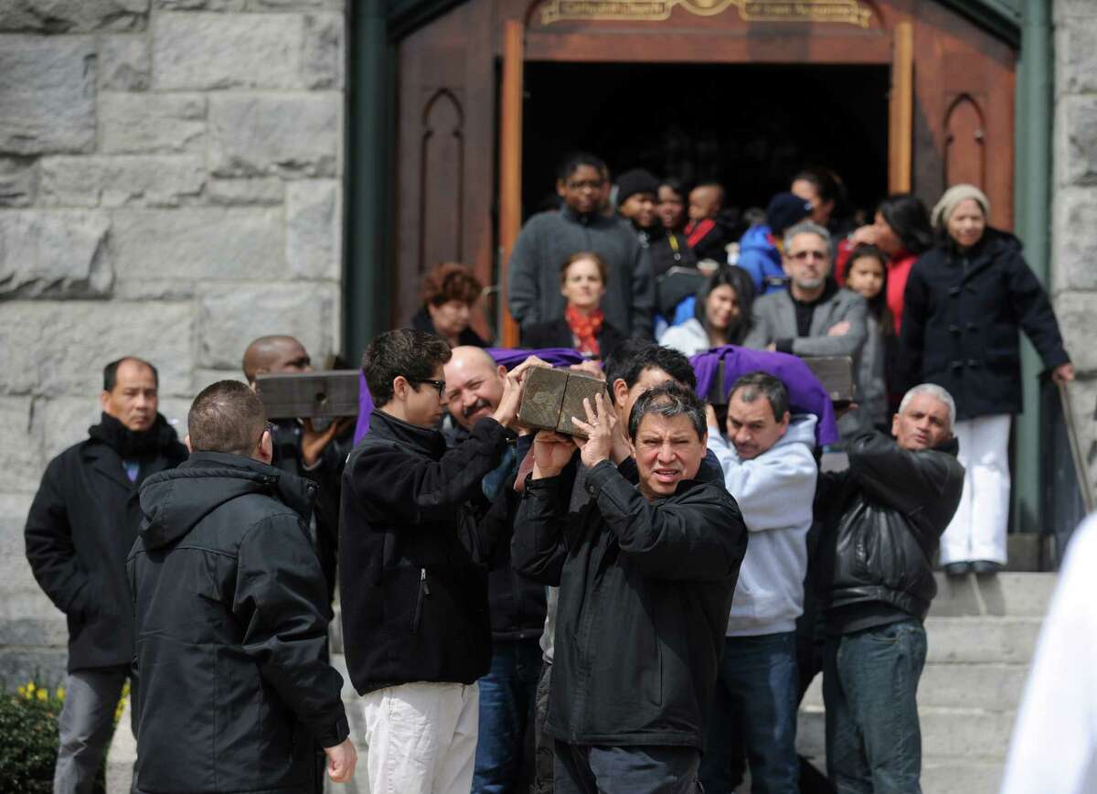 Parishioners carry the cross out of St. Augustine Cathedral during the Good Friday Passion of the Lord Multi-lingual Stations of the Cross Procession to St. Patrick Church Friday, April 18, 2014, in Bridgeport, Conn.