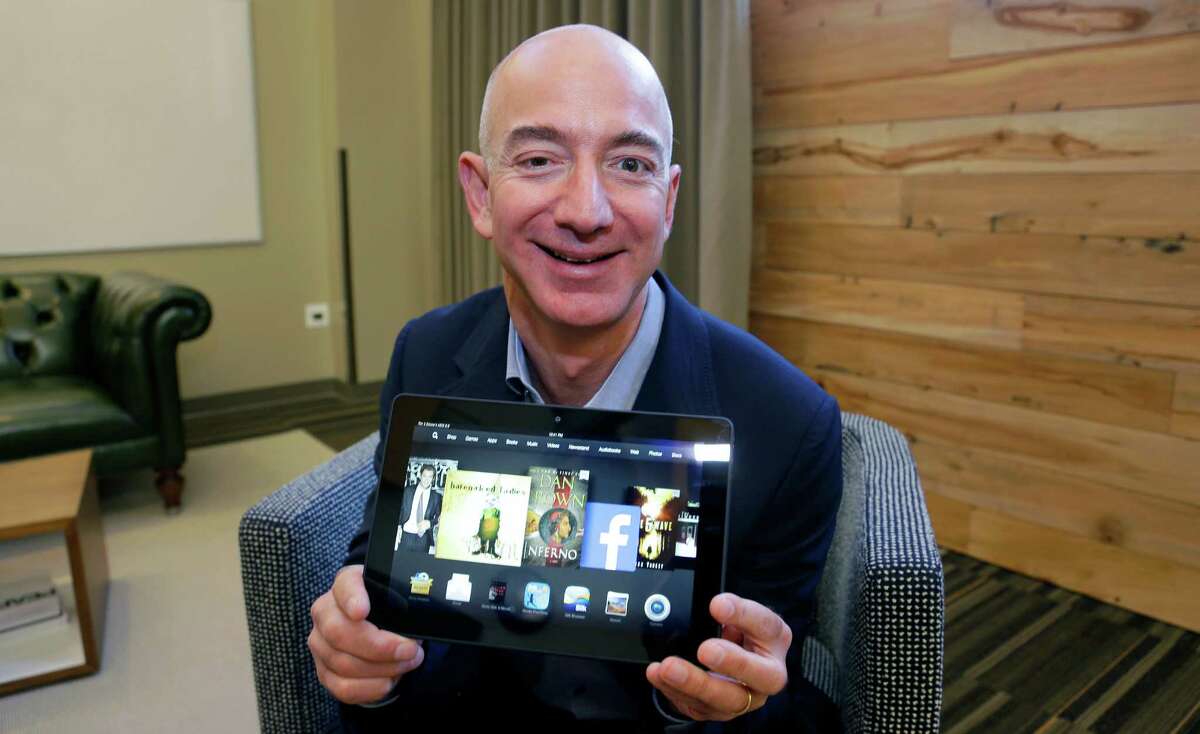 FILE - In a Sept. 24, 2013, file photo Jeff Bezos, CEO of Amazon.com, holds the 8.9-inch version of the new Amazon Kindle HDX tablet computer in Seattle. An official in the Galapagos Islands says that Amazon founder Jeff Bezos was flown by helicopter from a cruise ship on Jan. 1, 2014 for medical attention after suffering intense pain because of a kidney stone. (AP Photo/Ted S. Warren, File)