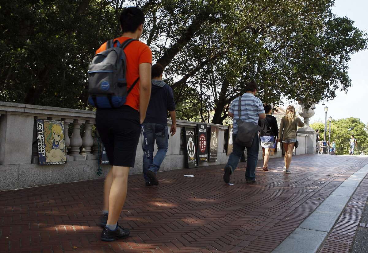 People walk past signs advertising various clubs to prospective students at the UC Berkeley campus on April 18, 2014 in Berkeley, Calif. 